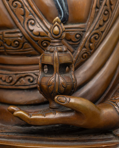 Detailed side view of Guru Shapdum Buddhist statue showing ritual objects and copper work