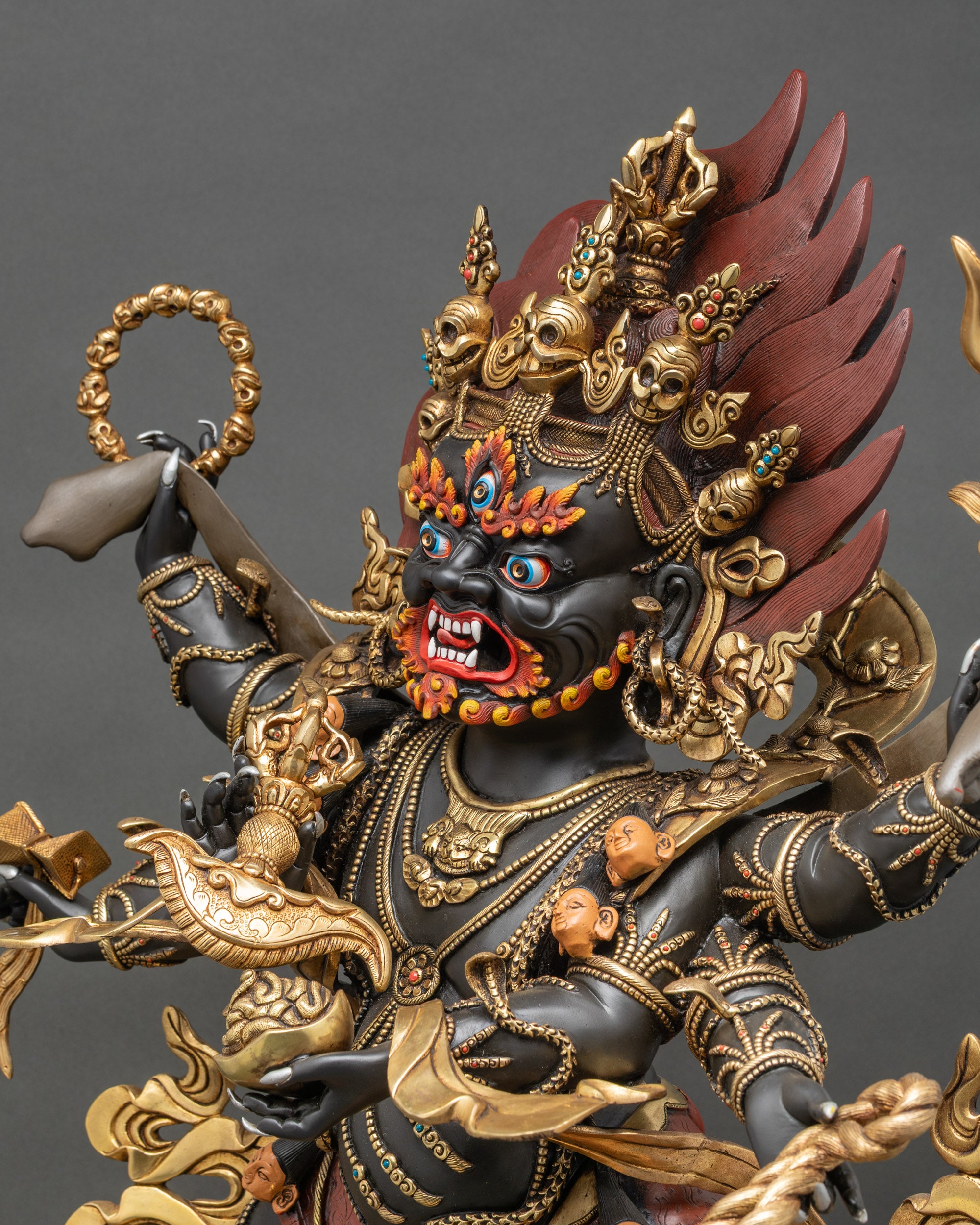 Detailed side view of Mahakala statue with gold-gilded robe and ornaments