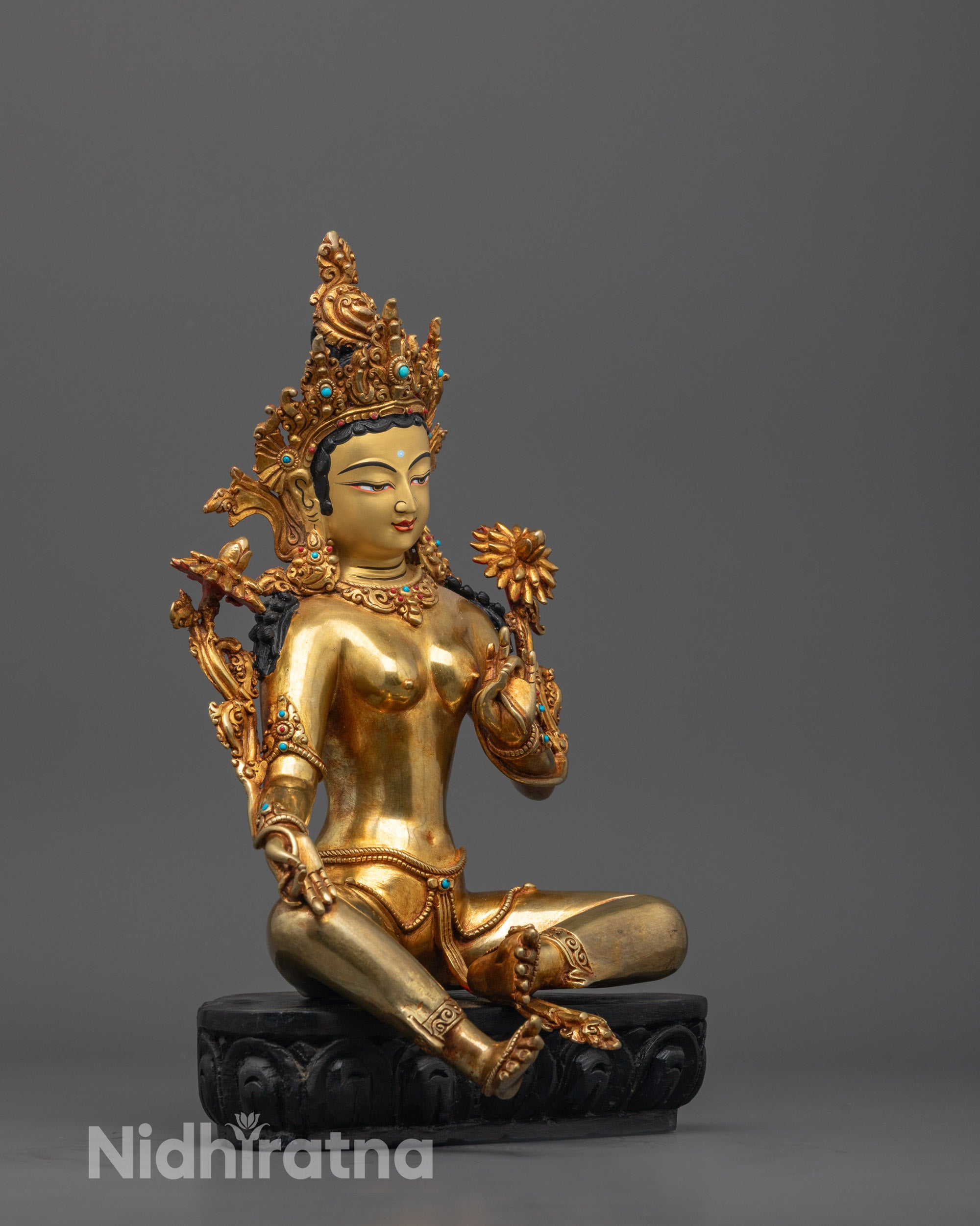 Detailed side view of the Green Tara sculpture showing serene posture