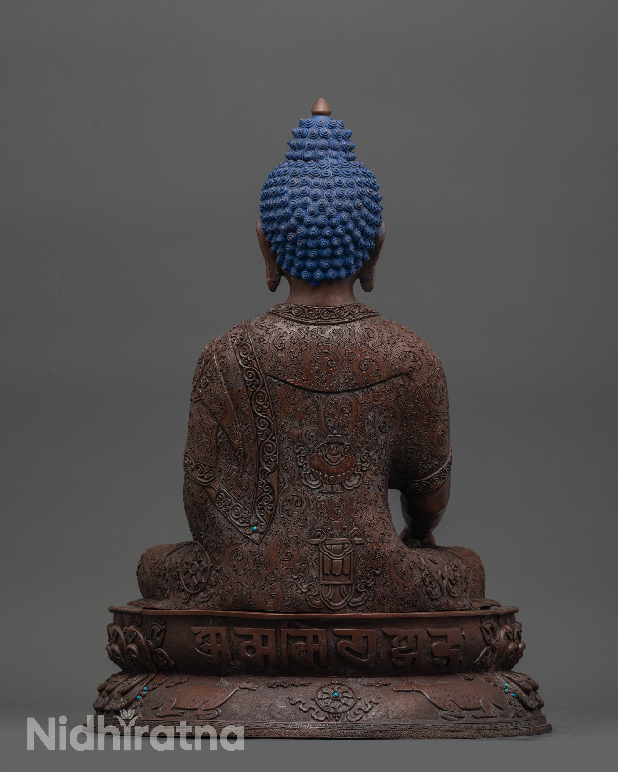 Detailed view of bhumisparsa mudra hand gesture on handcrafted oxidized copper statue
