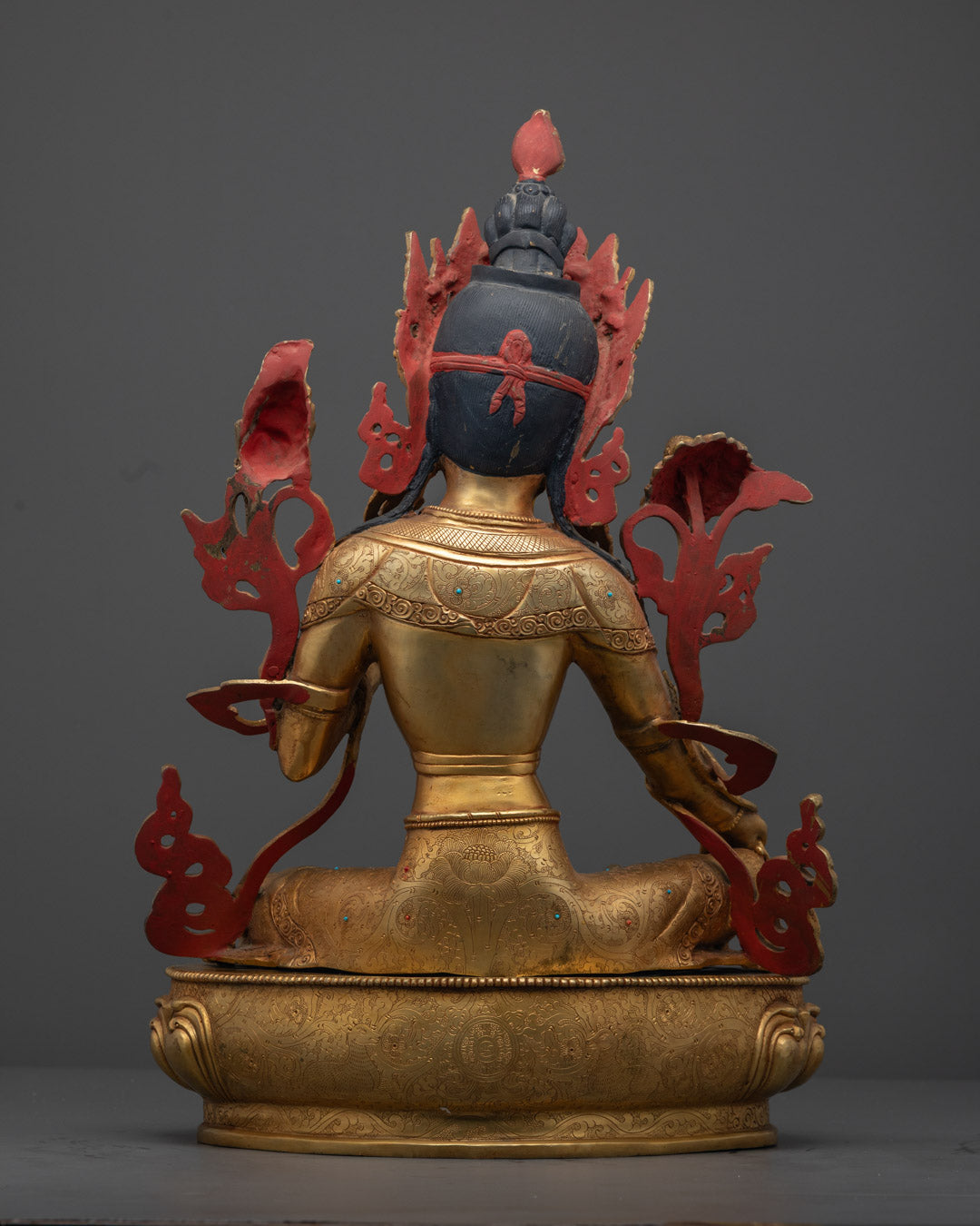 Detailed view of the hand-painted flowing robes and precious craftsmanship on a Green Tara Buddhist sculpture made in Nepal.