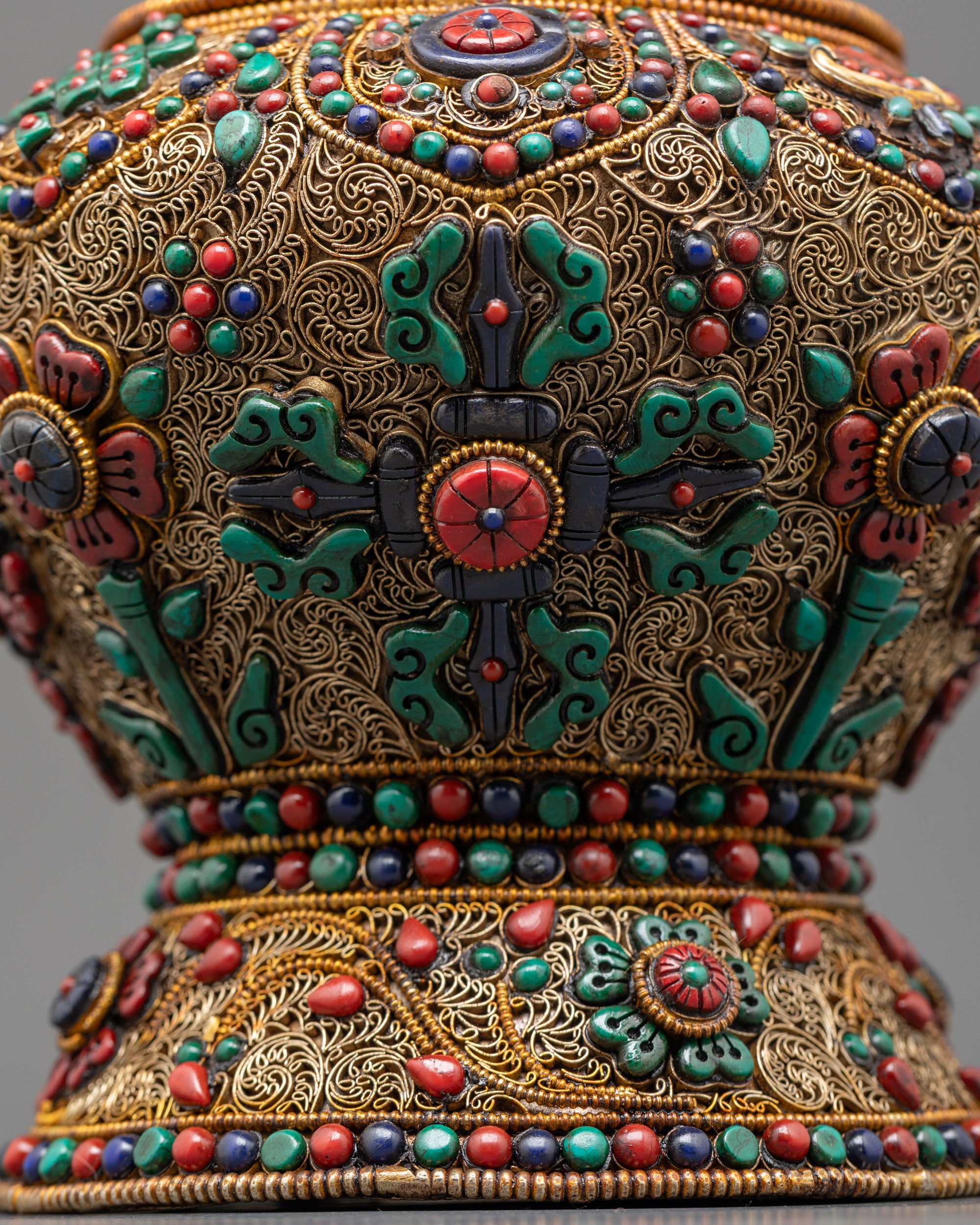 Detailed view of vishwa vajra on ricepot body highlighting coral, turquoise, and lapis lazuli inlays