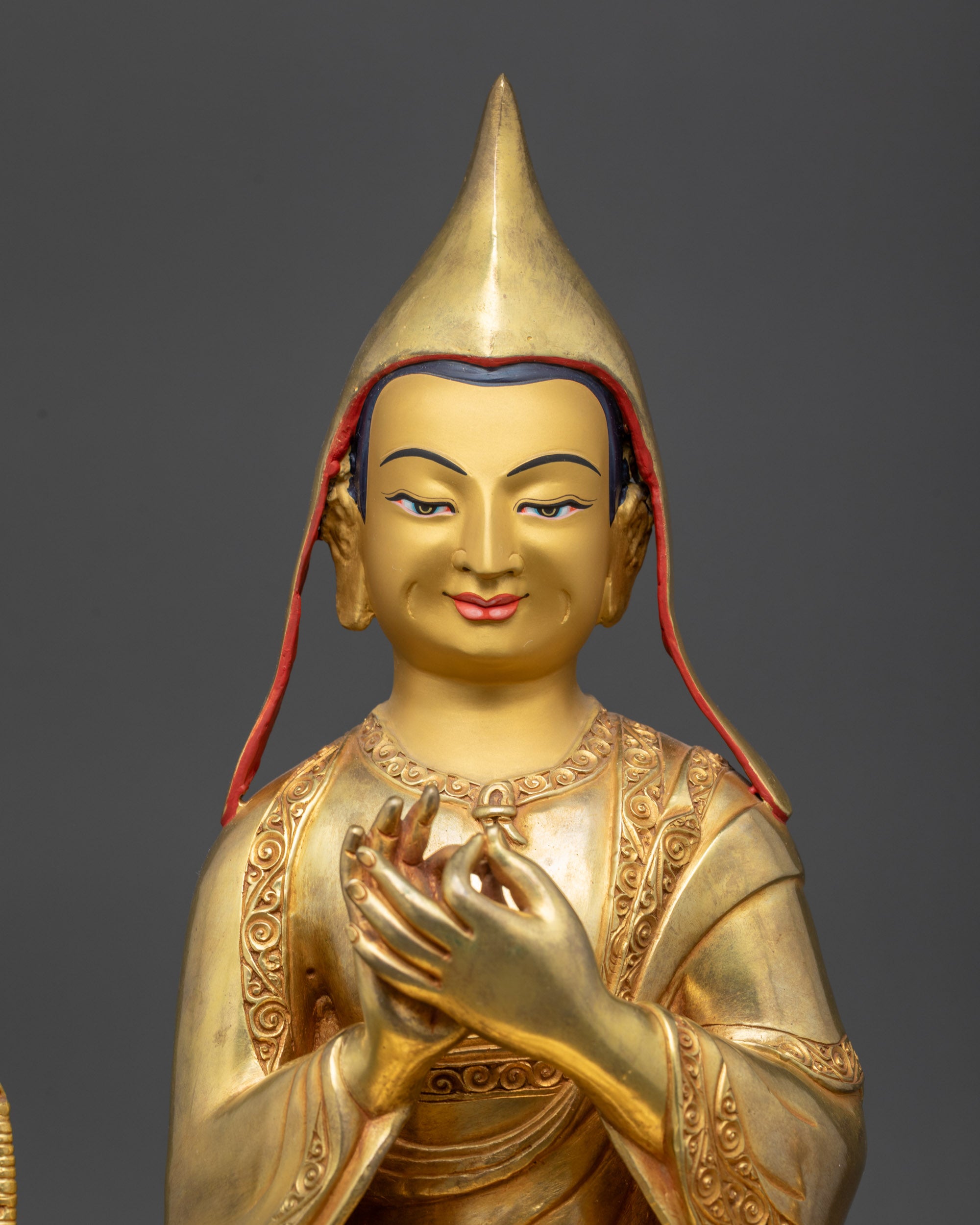 Dipankara Atisha statue close up highlighting gold-gilded face and serene expression

