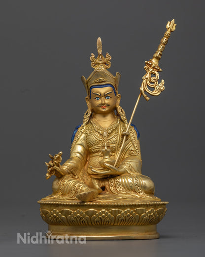 Discover the stunning 24.5cm tall Guru Rinpoche deity statue, handcrafted by skilled Nepalese artisans. This gold-plated statue features detailed carvings on the robe and jewelry, symbolizing wisdom and spiritual power