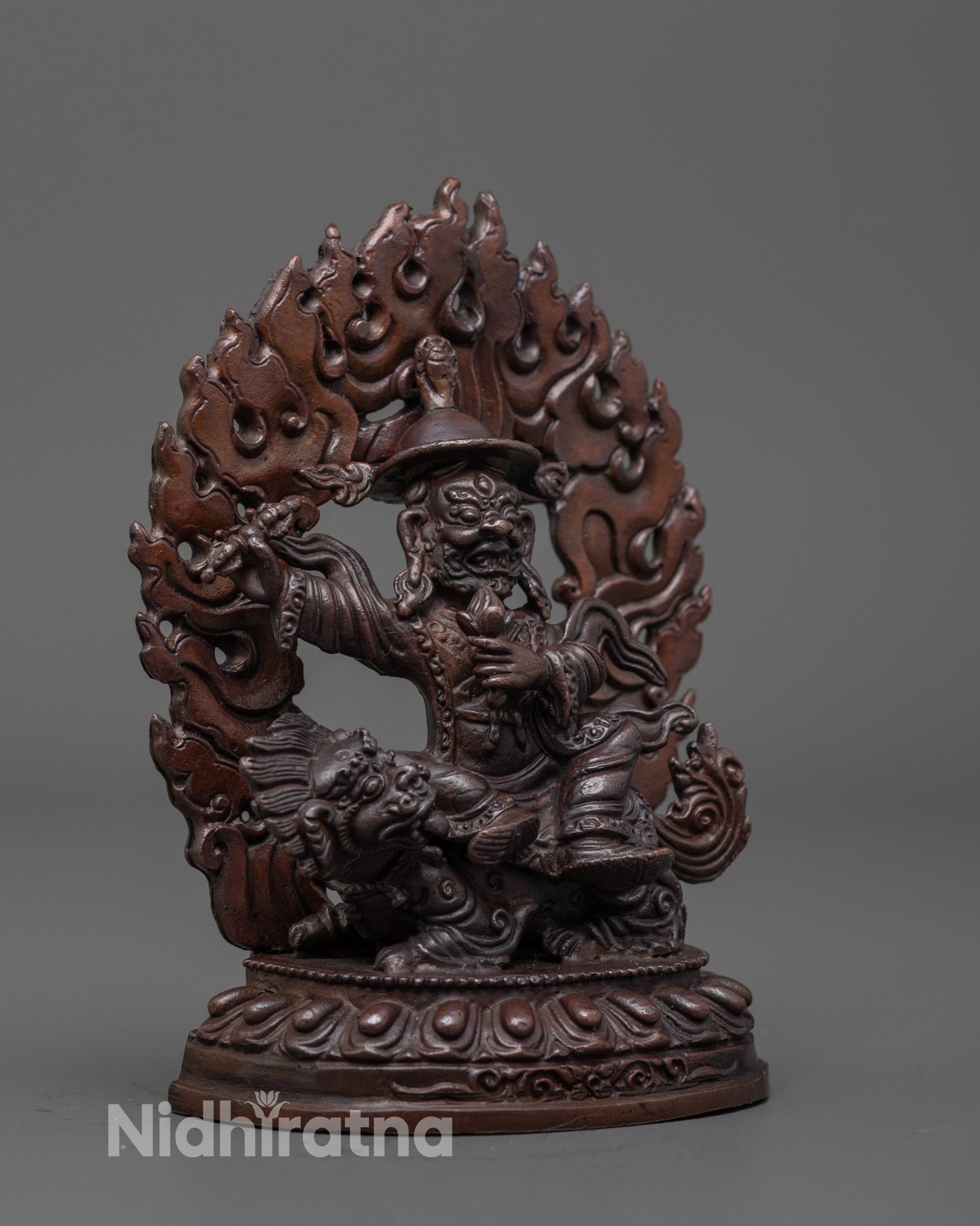 Side angle of Dorje Lekpa statue showing flowing robes, wide-brimmed hat, and vajra detail
