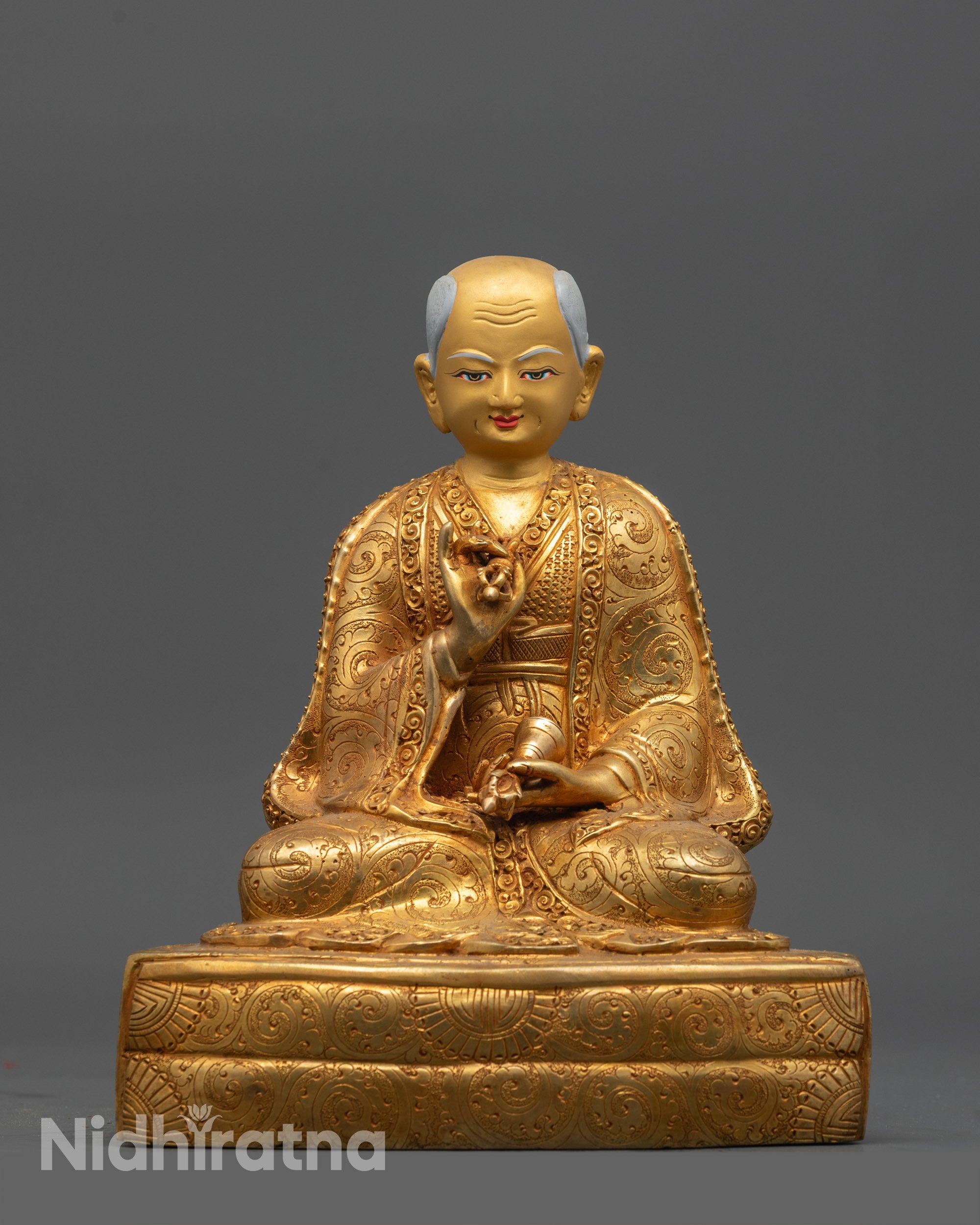 Drakpa Gyaltsen holding vajra and bell, detailed gold fire-gilded statue