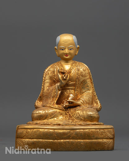 Drakpa Gyaltsen holding vajra and bell, detailed gold fire-gilded statue