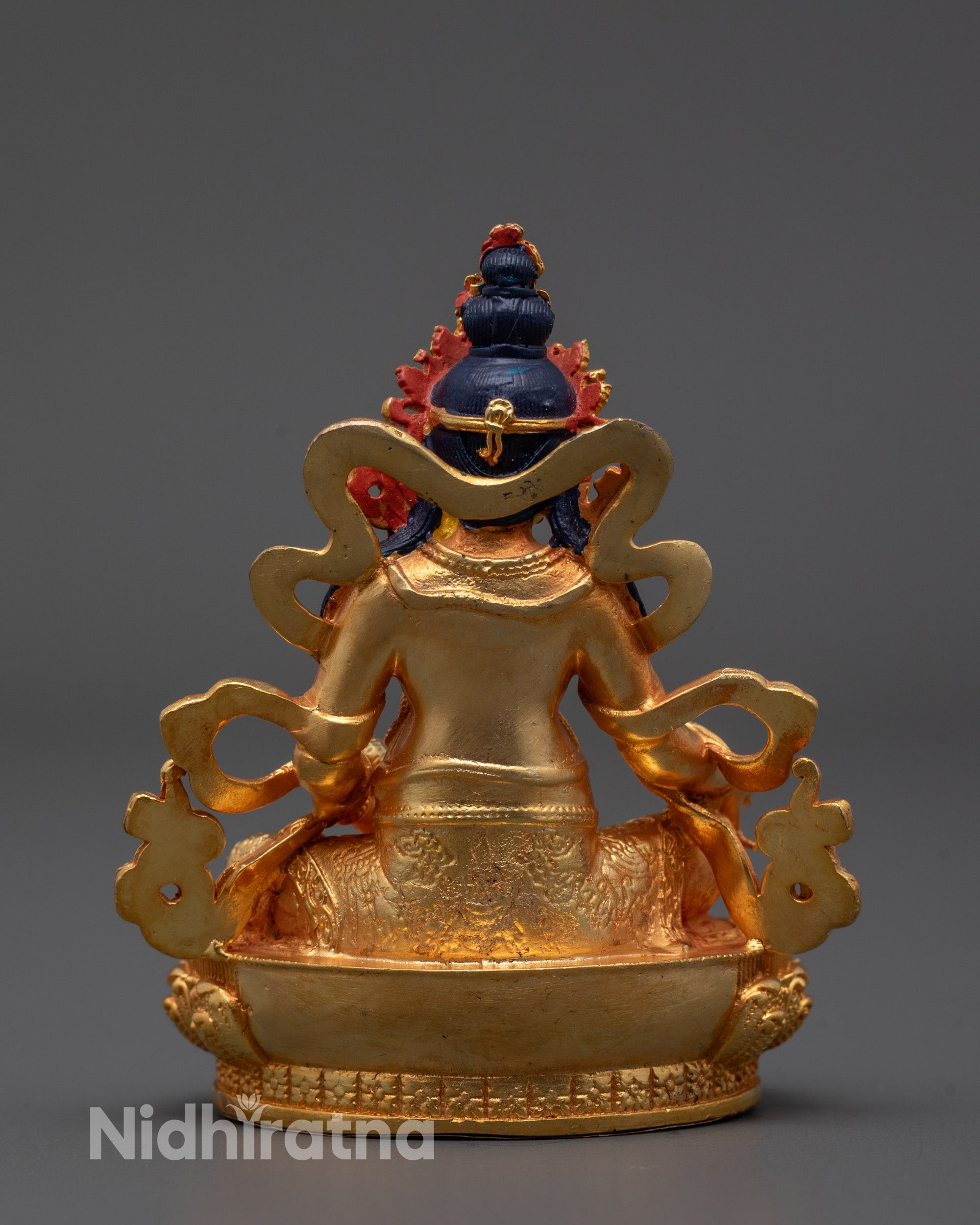back view of machine-made Jambhala statue with carved lower garment details