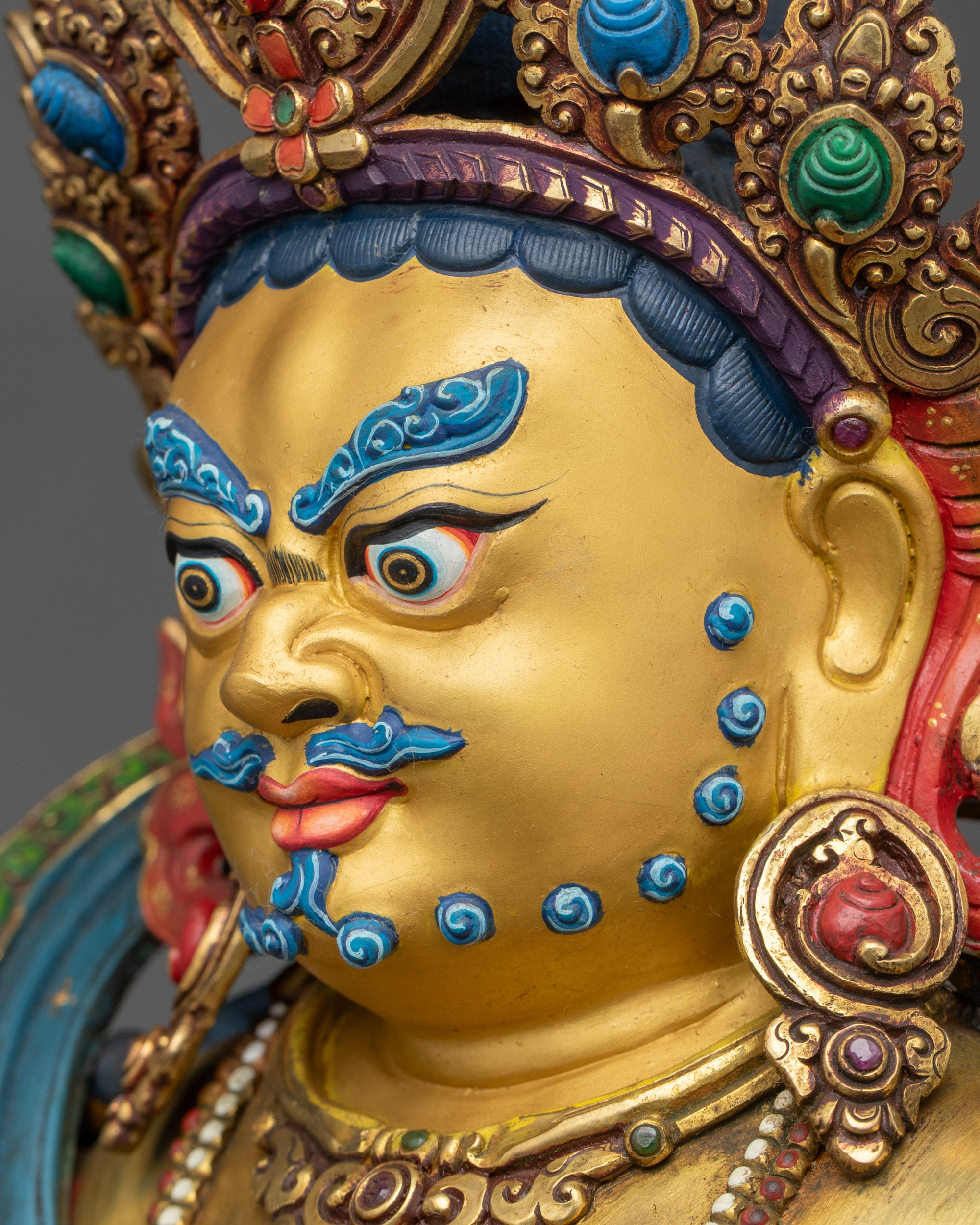 Dzambhala Statue detailed side close-up of face, highlighting citrons and jewels