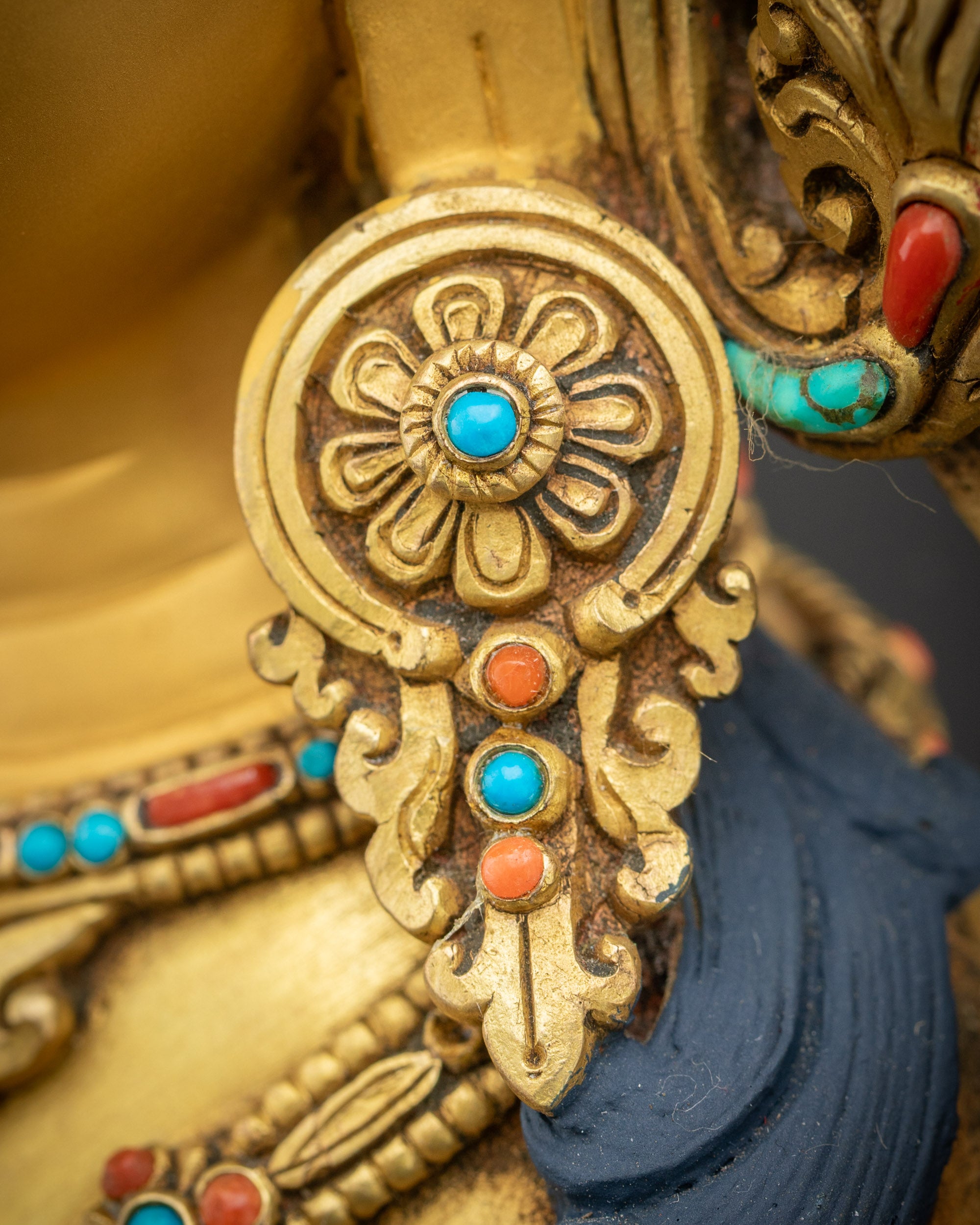 Earrings close up with intricate carving and semi-precious stones