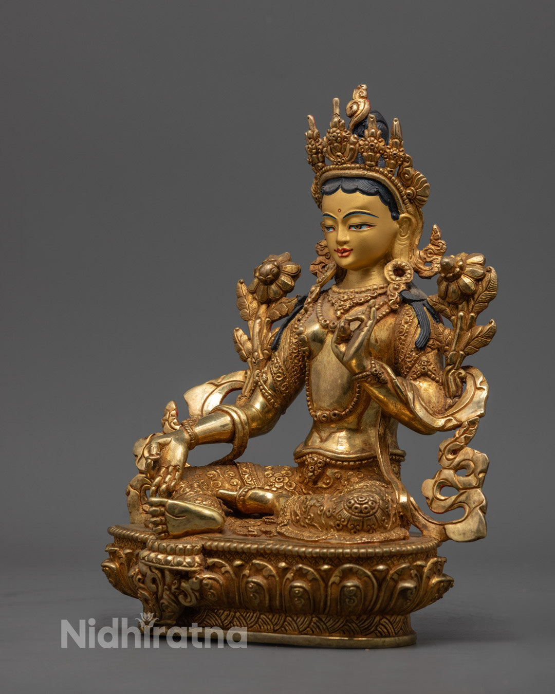Elegant Green Tara statue symbolizing compassion and protection, adorned with fire-gilded copper and colorful semi-precious stones.