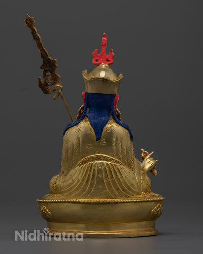 Enhance your spiritual space with this 24.5cm tall Guru Rinpoche statue, handcrafted in Nepal with intricate carvings and a gold-plated finish, symbolizing spiritual mastery and devotion.