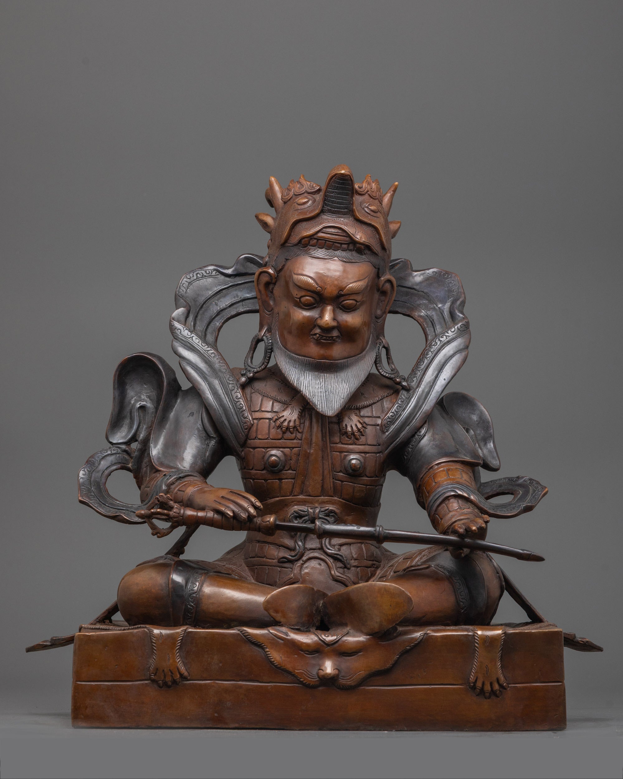 Exquisite Virudhaka sculpture crafted in oxidized copper, seated gracefully