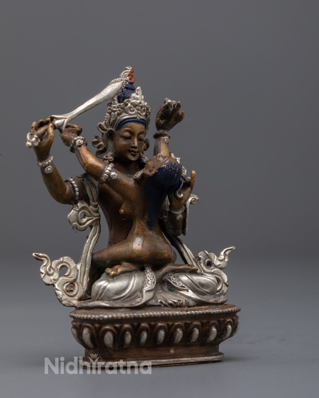 Exquisite carvings on Manjushri’s flowing robe, jewelry, and sacred uptala flower