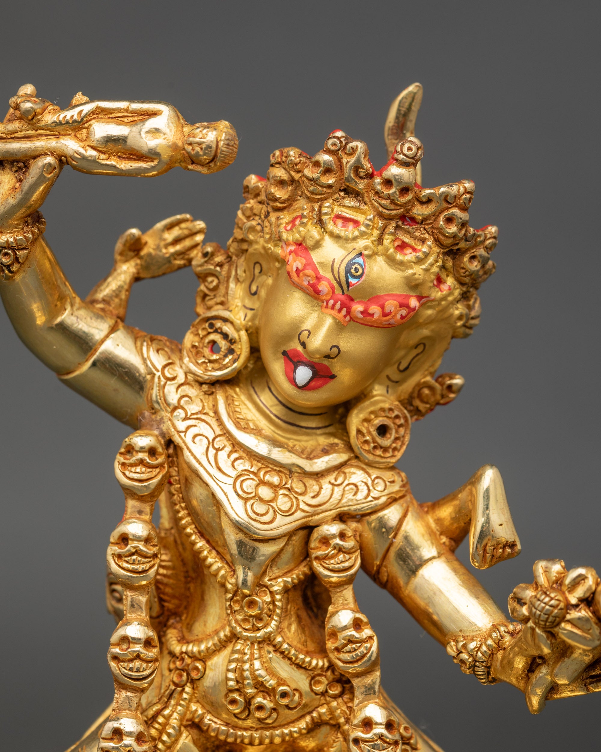 Close up: Close up Ekajati face, single eye, gold-painted, adorned with skull necklace and details