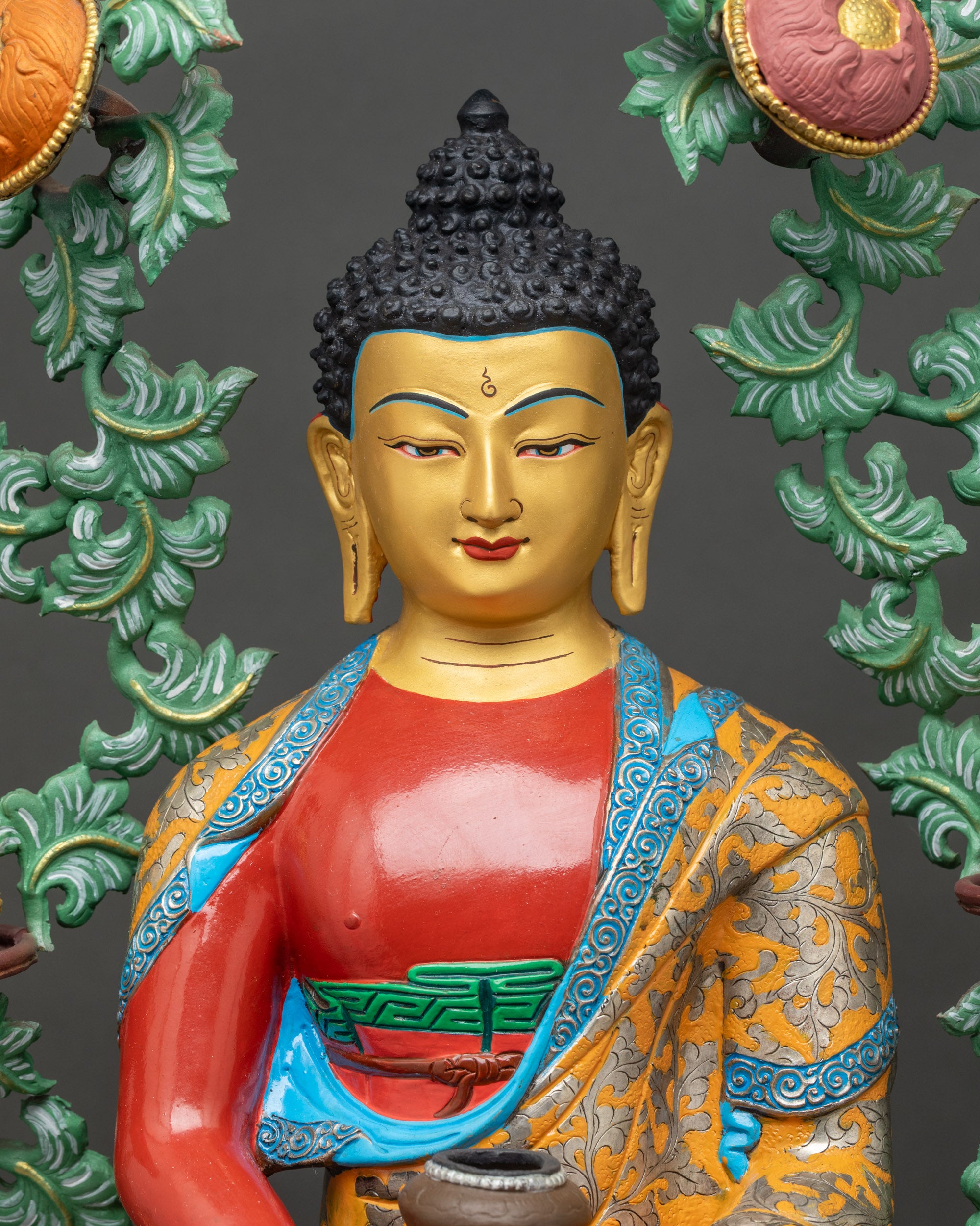 Close up Amitabha Buddha gold-painted face and vibrant hand-applied robes