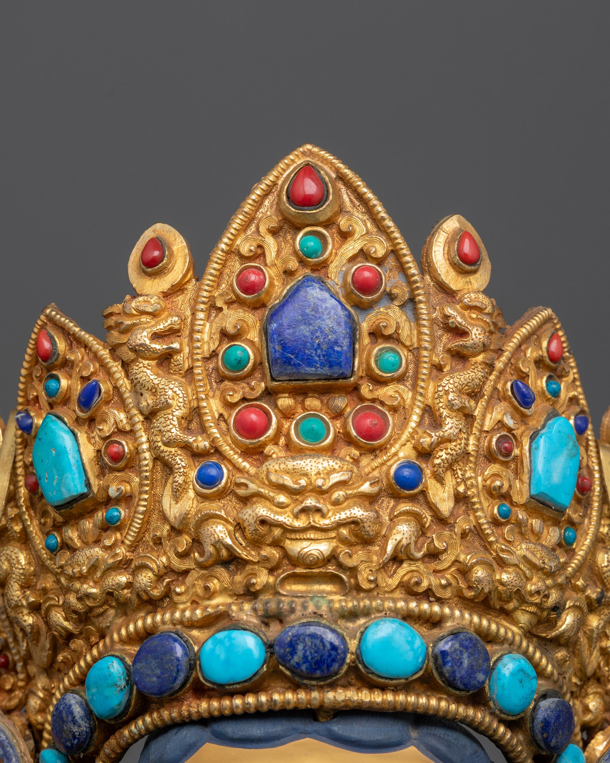 Close up of Dzambhala crown with five-jewel design and carved auspicious motifs