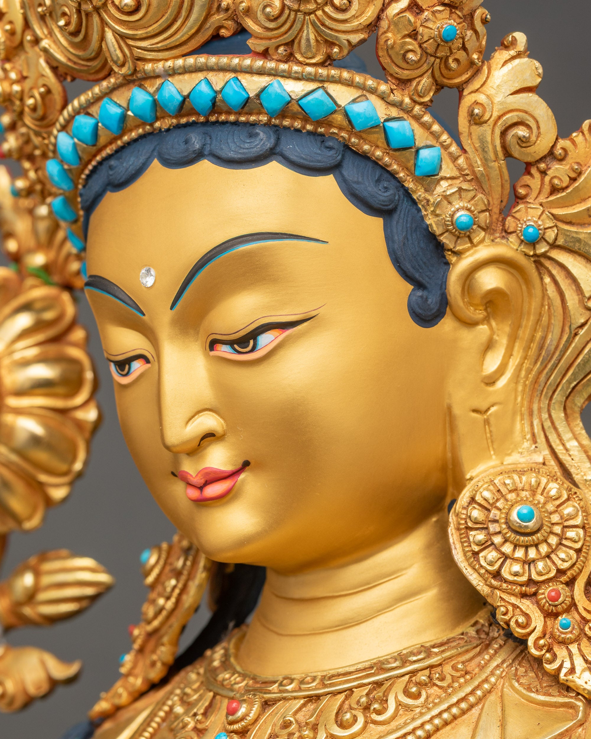 Green Tara Statue side close up face serene gold-gilded visage