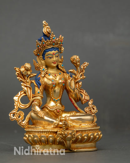 Side view Green Tara statue seated on lotus throne, Varada Mudra, extended leg