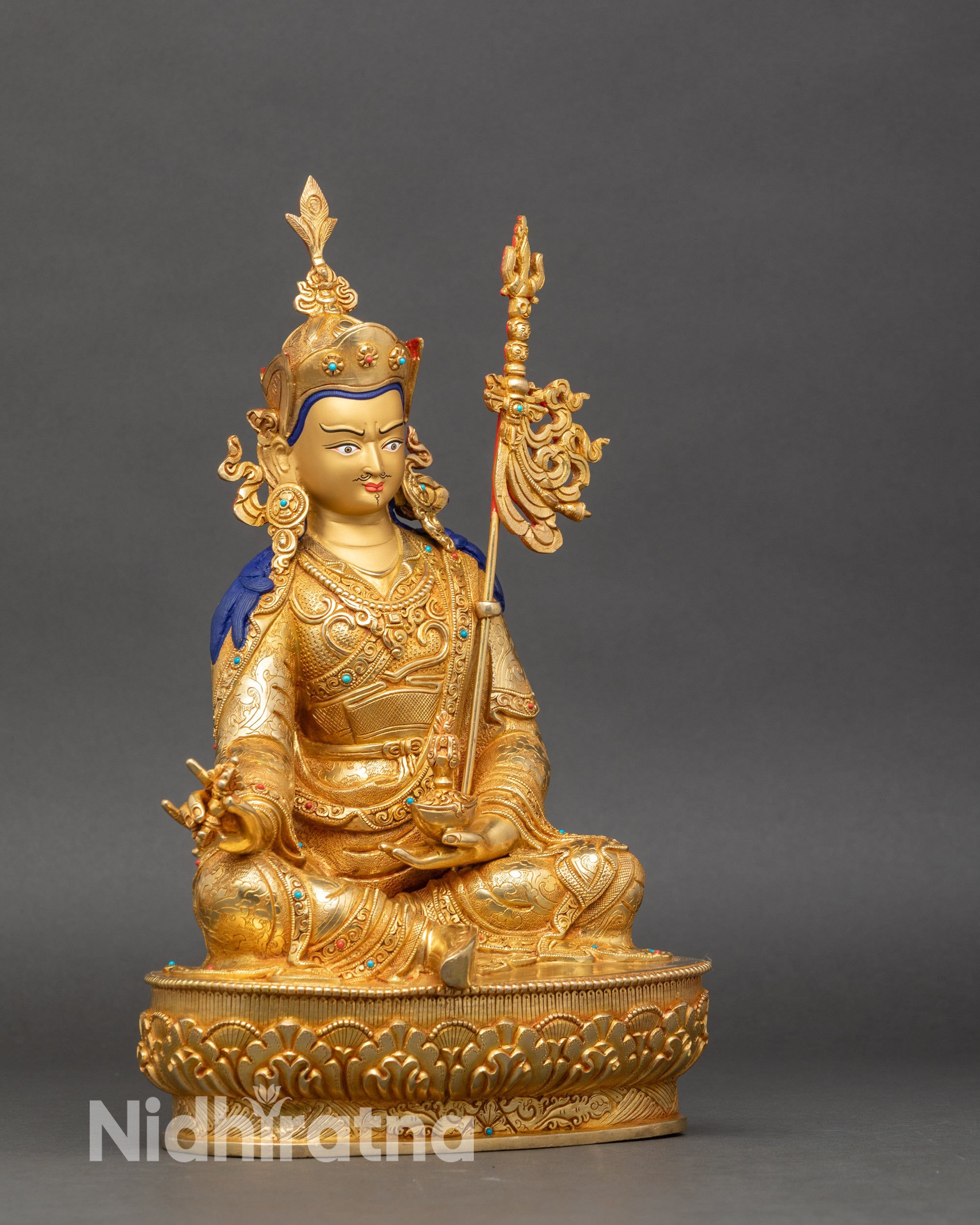 Right profile of Guru Rinpoche statue holding vajra and skullcup, copper and gold-gilded craftsmanship