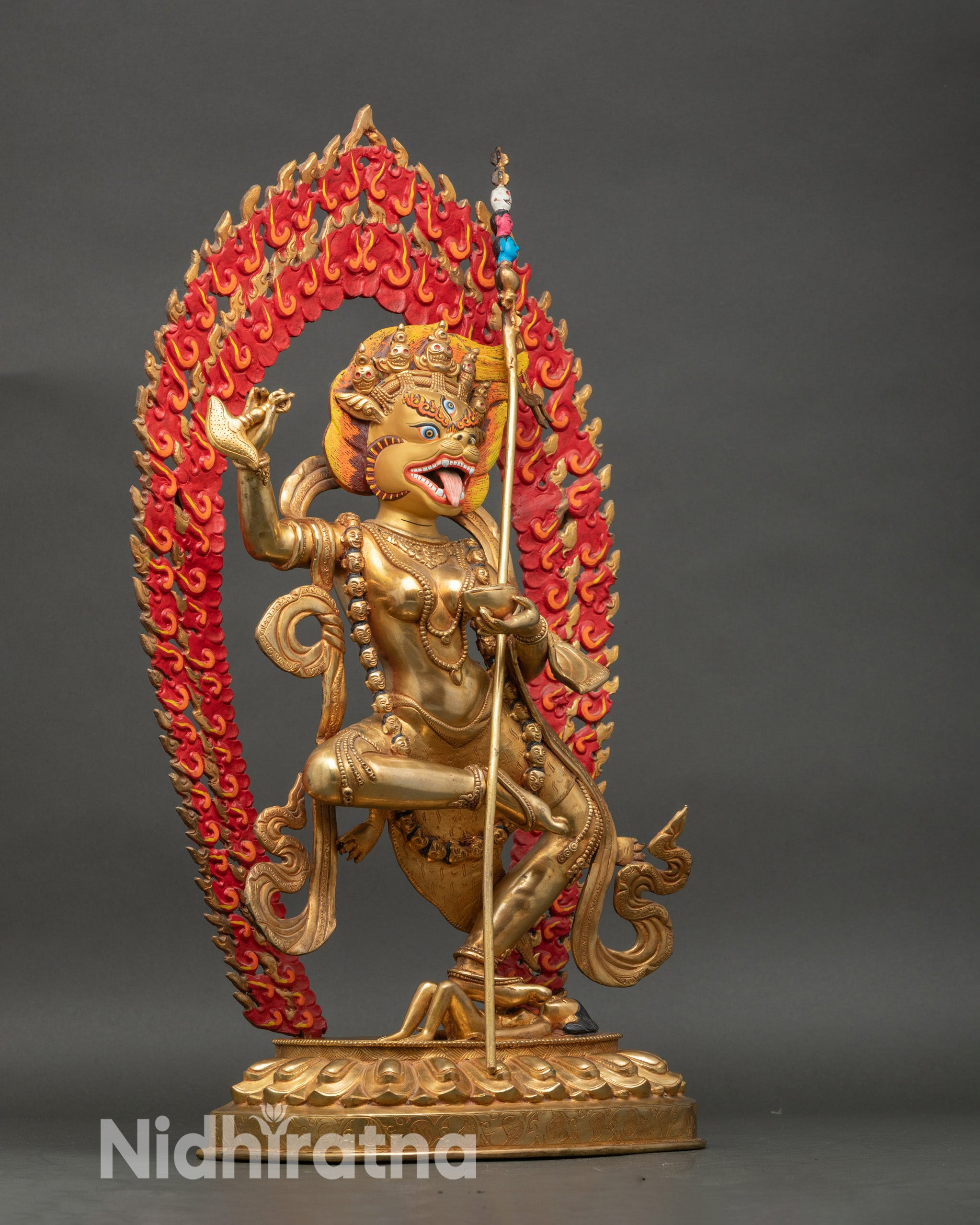 Side view Simhamukha statue highlighting dynamic robes, ritual weapons, and flowing garments