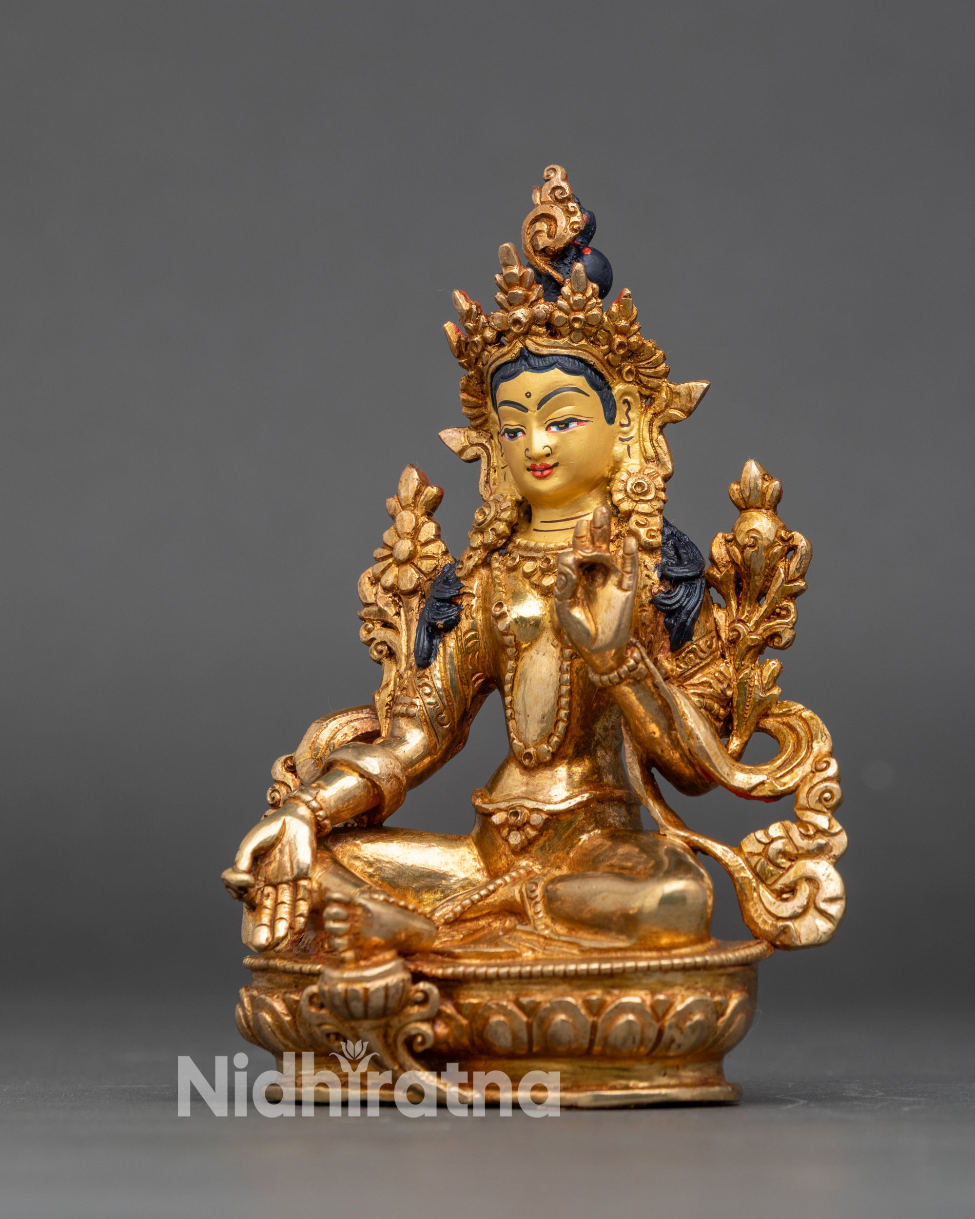 Green Tara figurine seated on lotus throne, symbol of compassion and protection