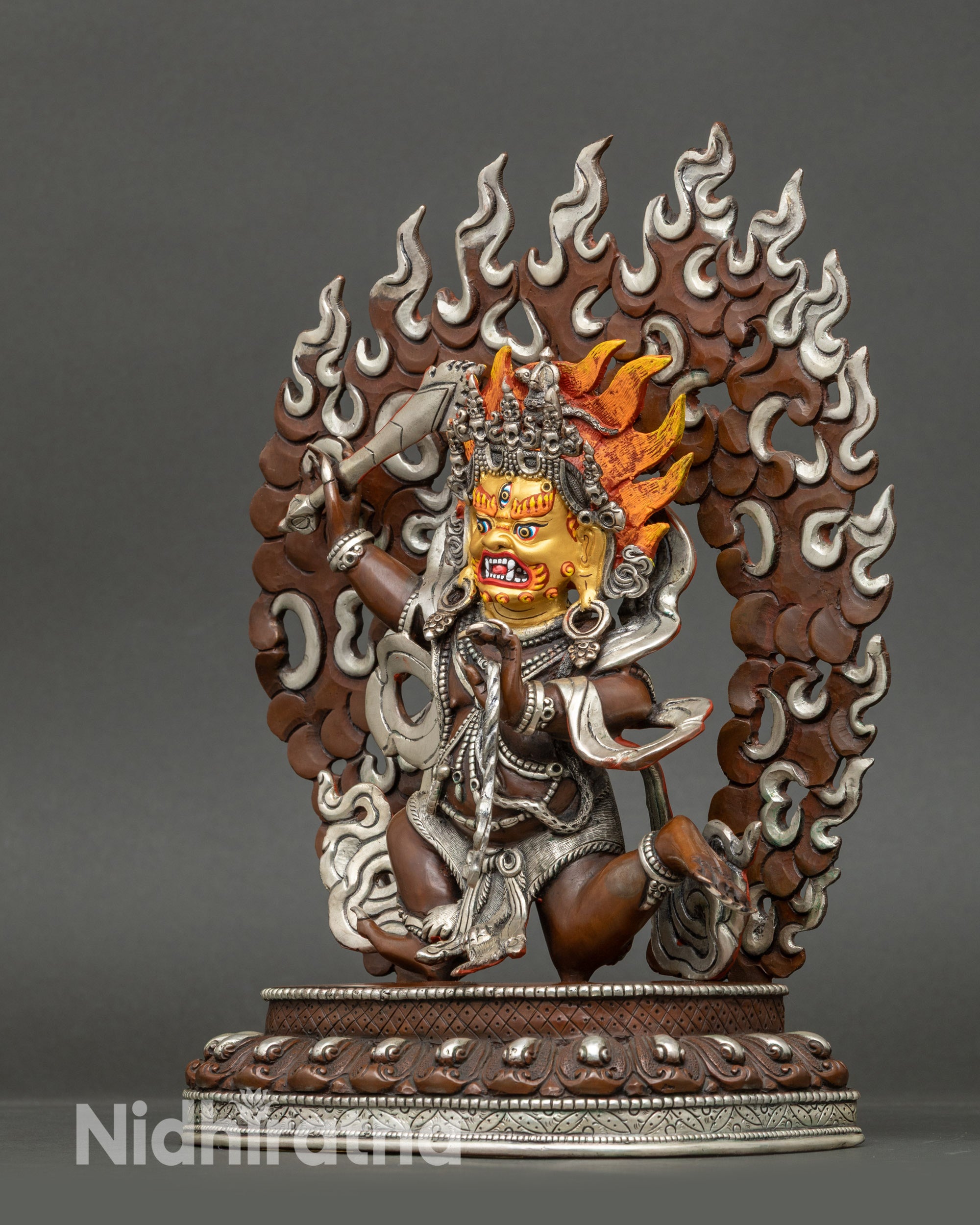 Side view of Achala statue on lotus seat, silver-plated and oxidized copper with divine protection symbolism