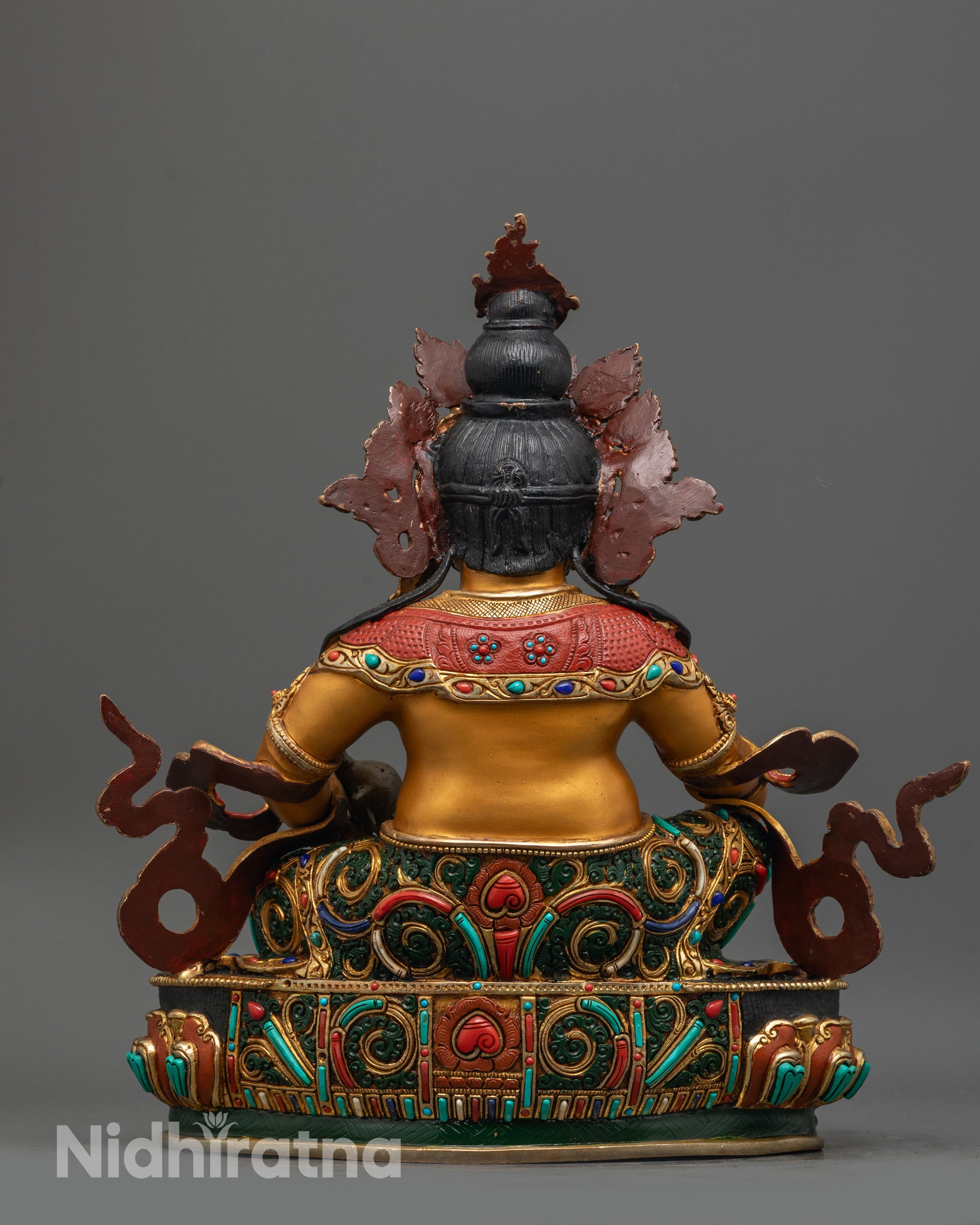 Back view of Dzambhala Statue displaying detailed lower garments adorned with stones