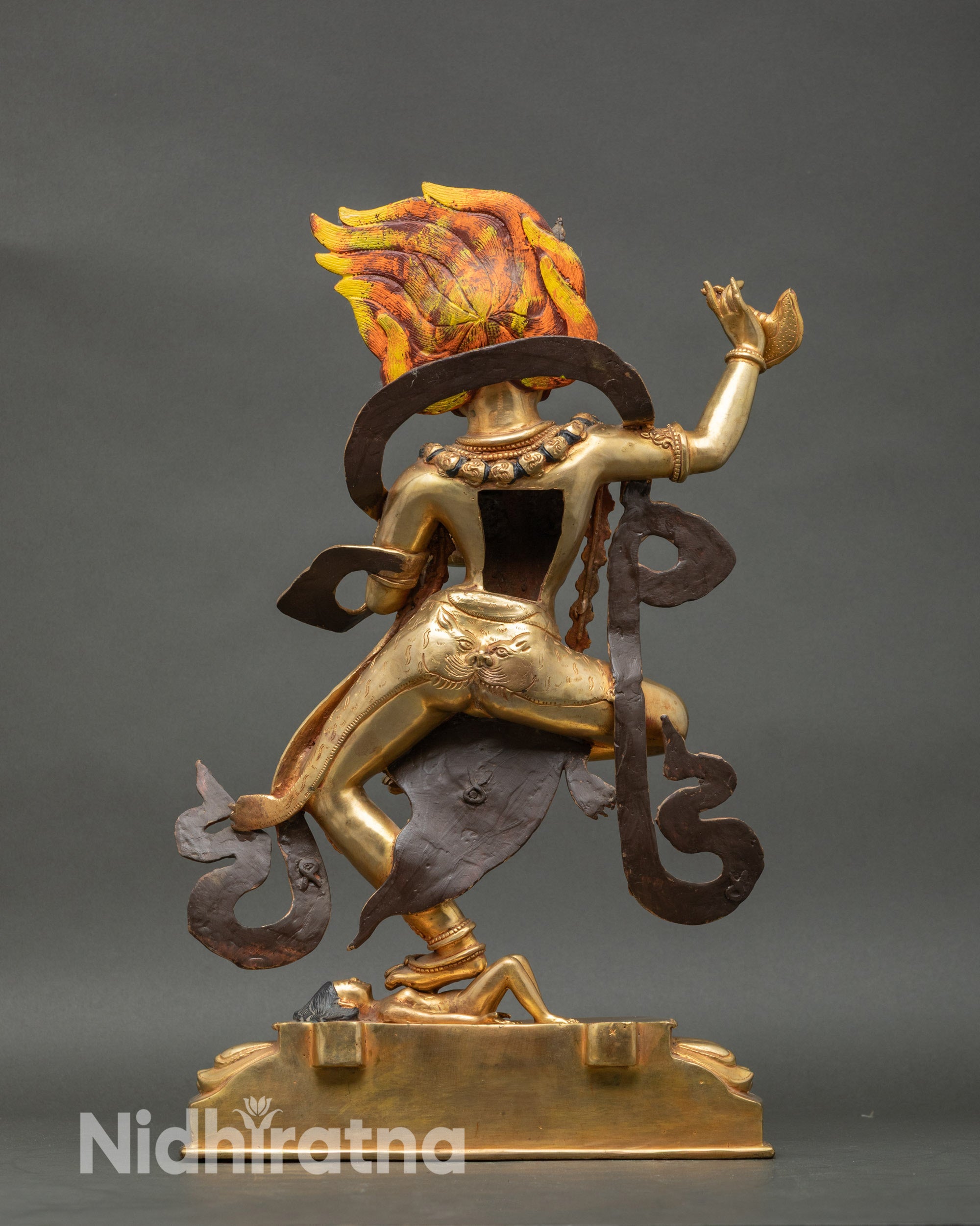 Back view Simhamukha statue showing carved robes, skull garland, and fiery halo details