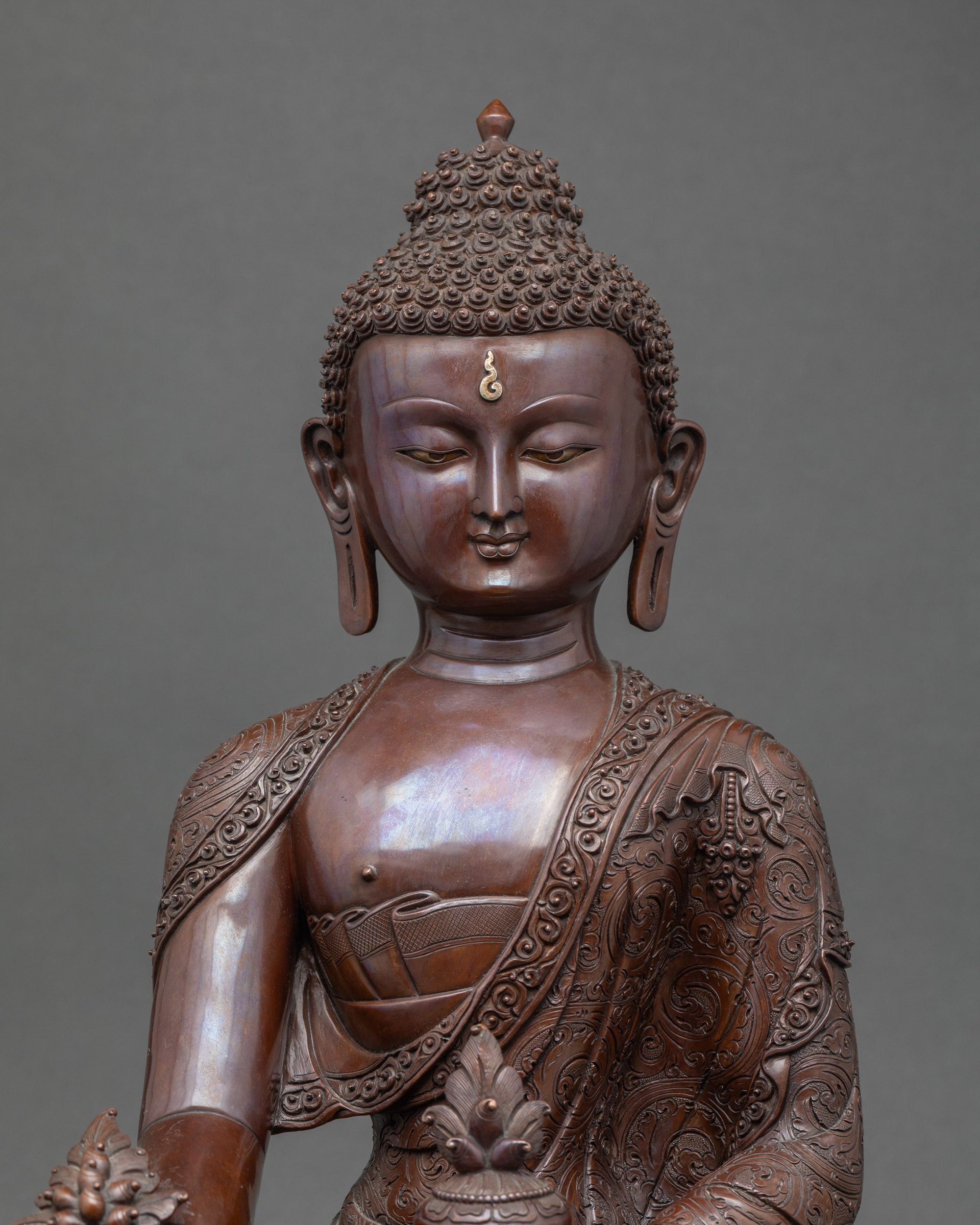 Close up of Medicine Buddha holding alms bowl and myrobalan plant for healing and wellness