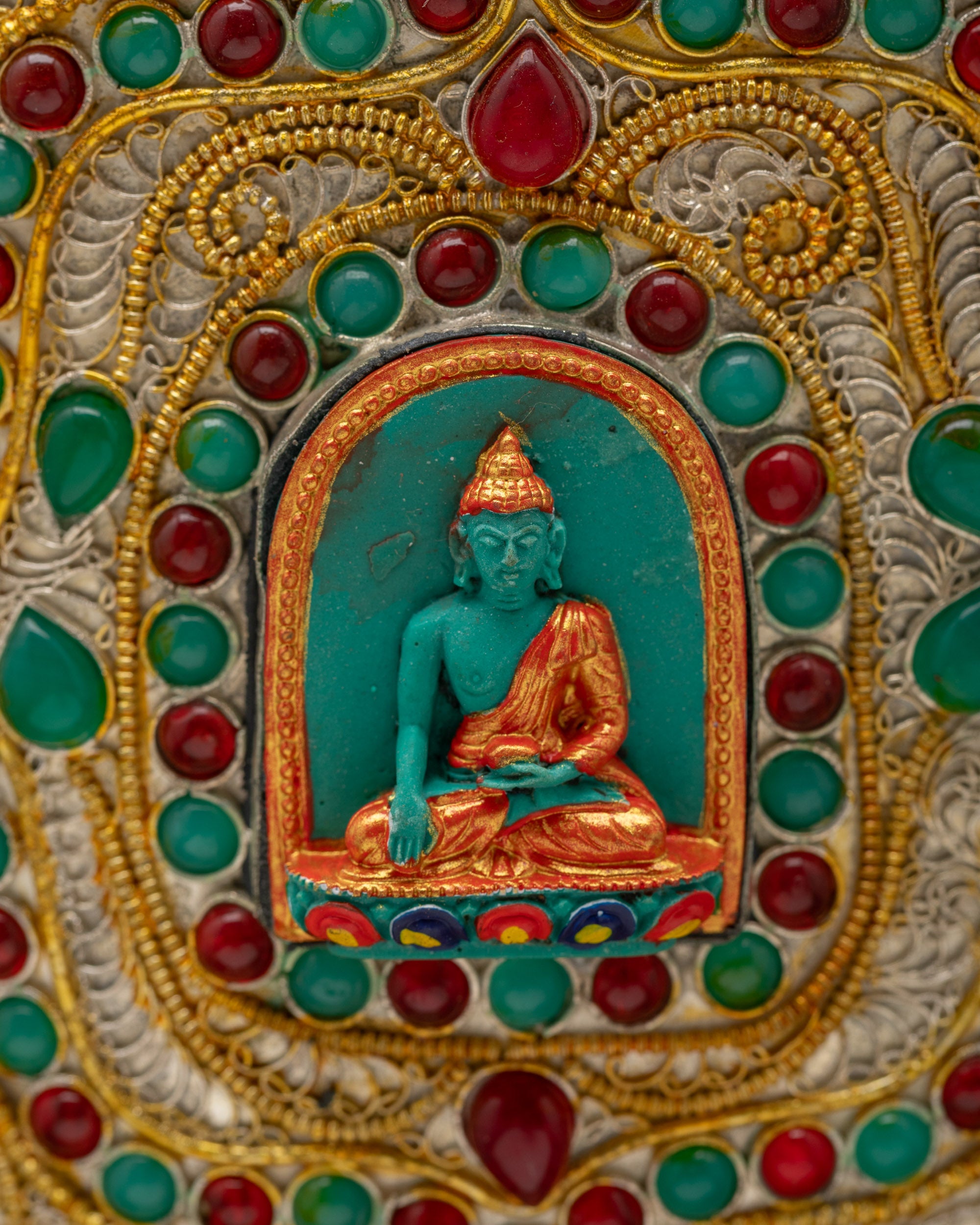 Close-up of Shakyamuni Buddha design on handcrafted Himalayan Flower Vase, adorned with sacred gemstone filigree work from Nepal.