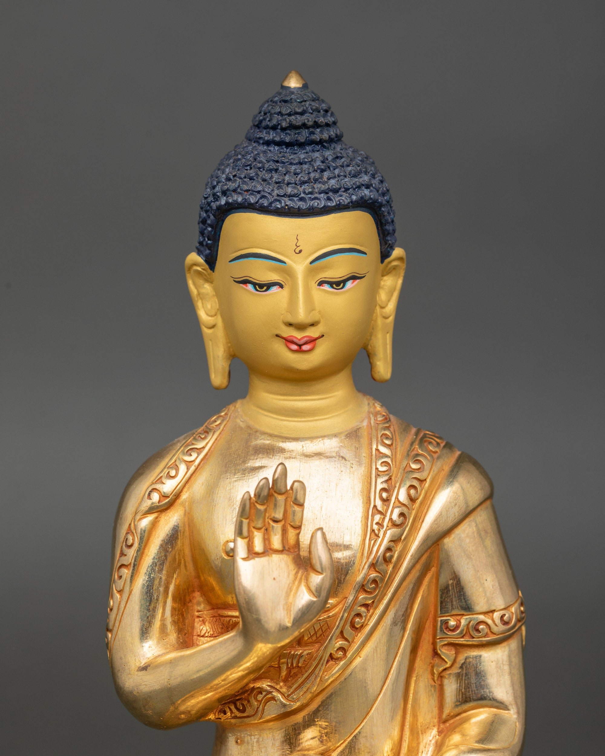 Close up Amoghasiddhi face with gold-painted features, polished monk’s robe, handcrafted Nepal