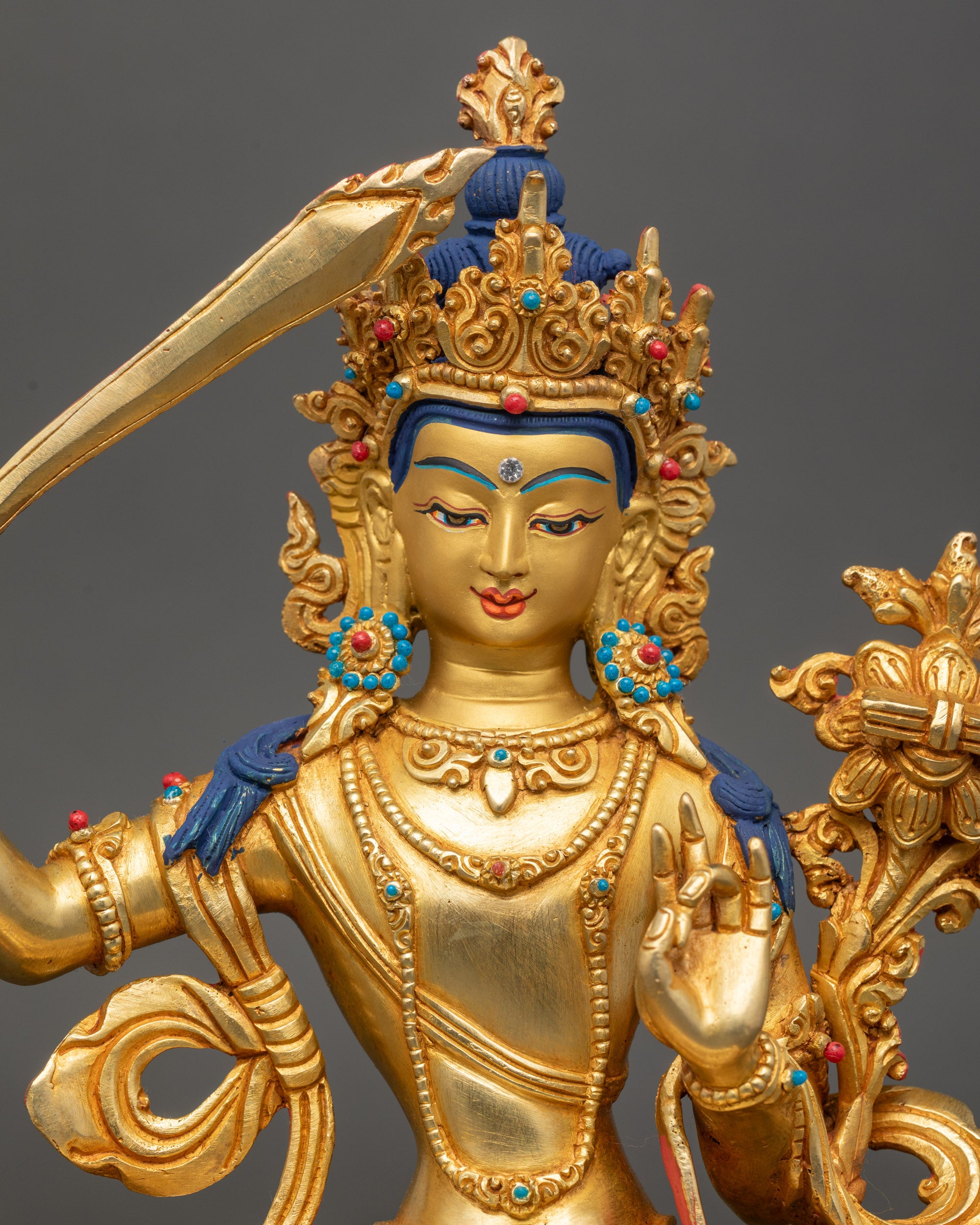 Close up Manjushree face, gold-painted expression with semi-precious stone crown