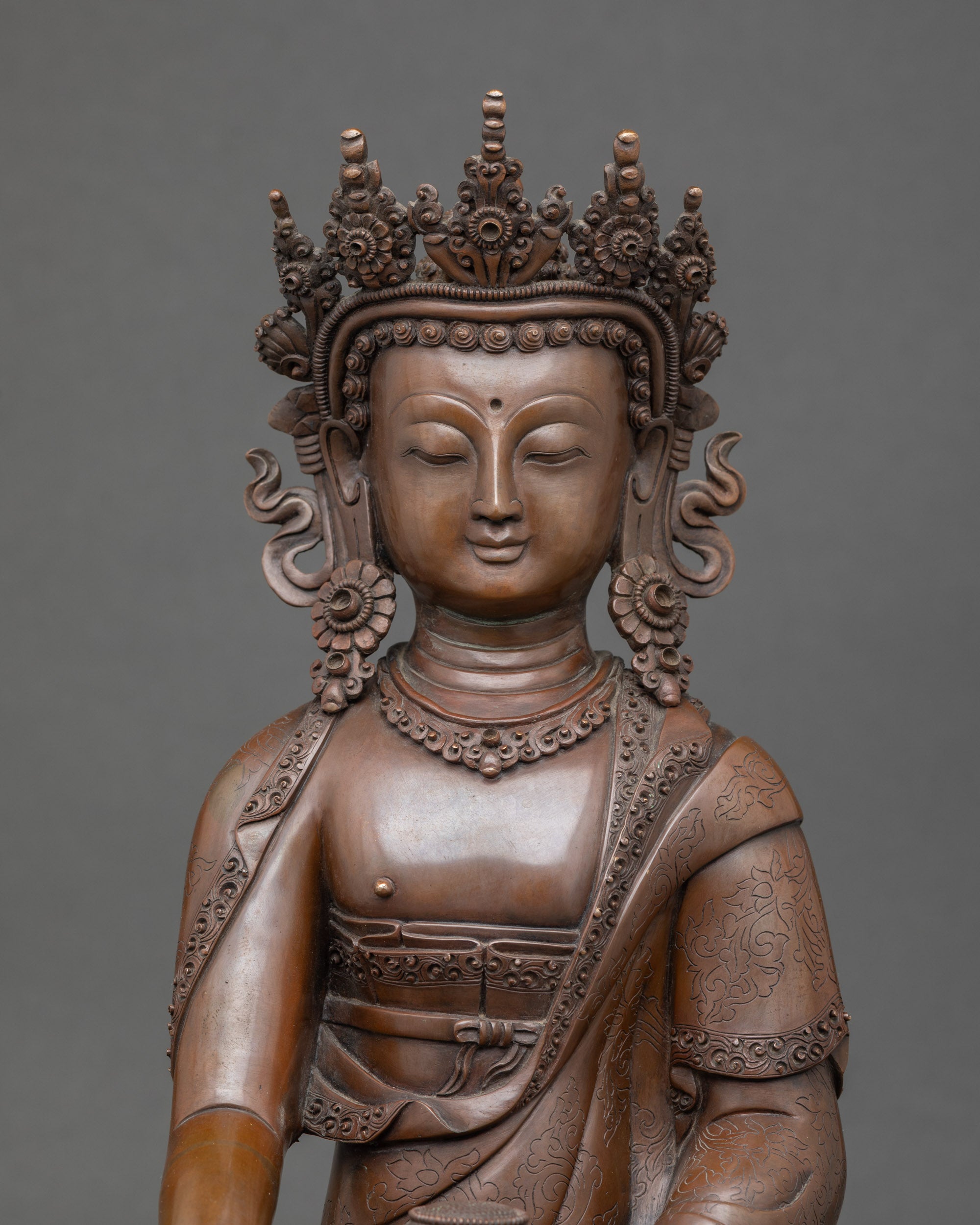 Close-up of Mitrugpa Buddha face showing crowned details and serene expression