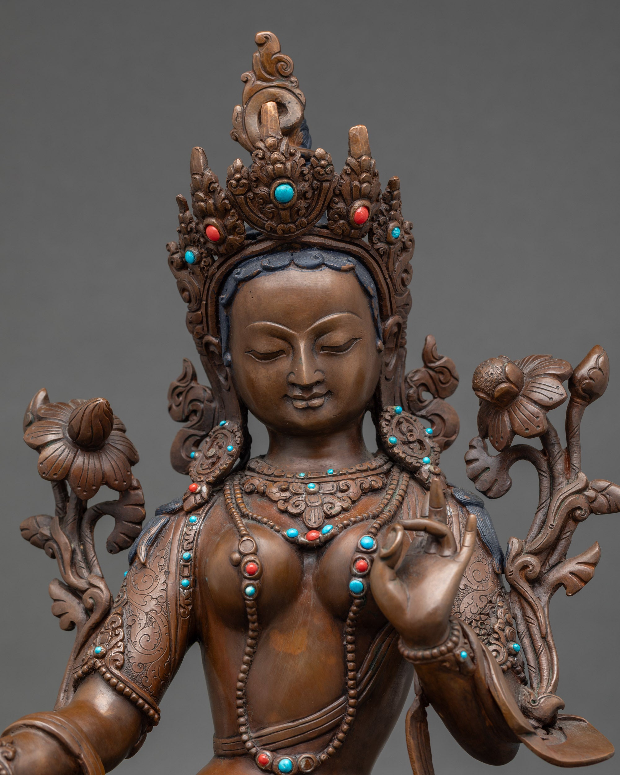 Close up of Green Tara holding blue lotus, handmade Nepalese copper Buddha
