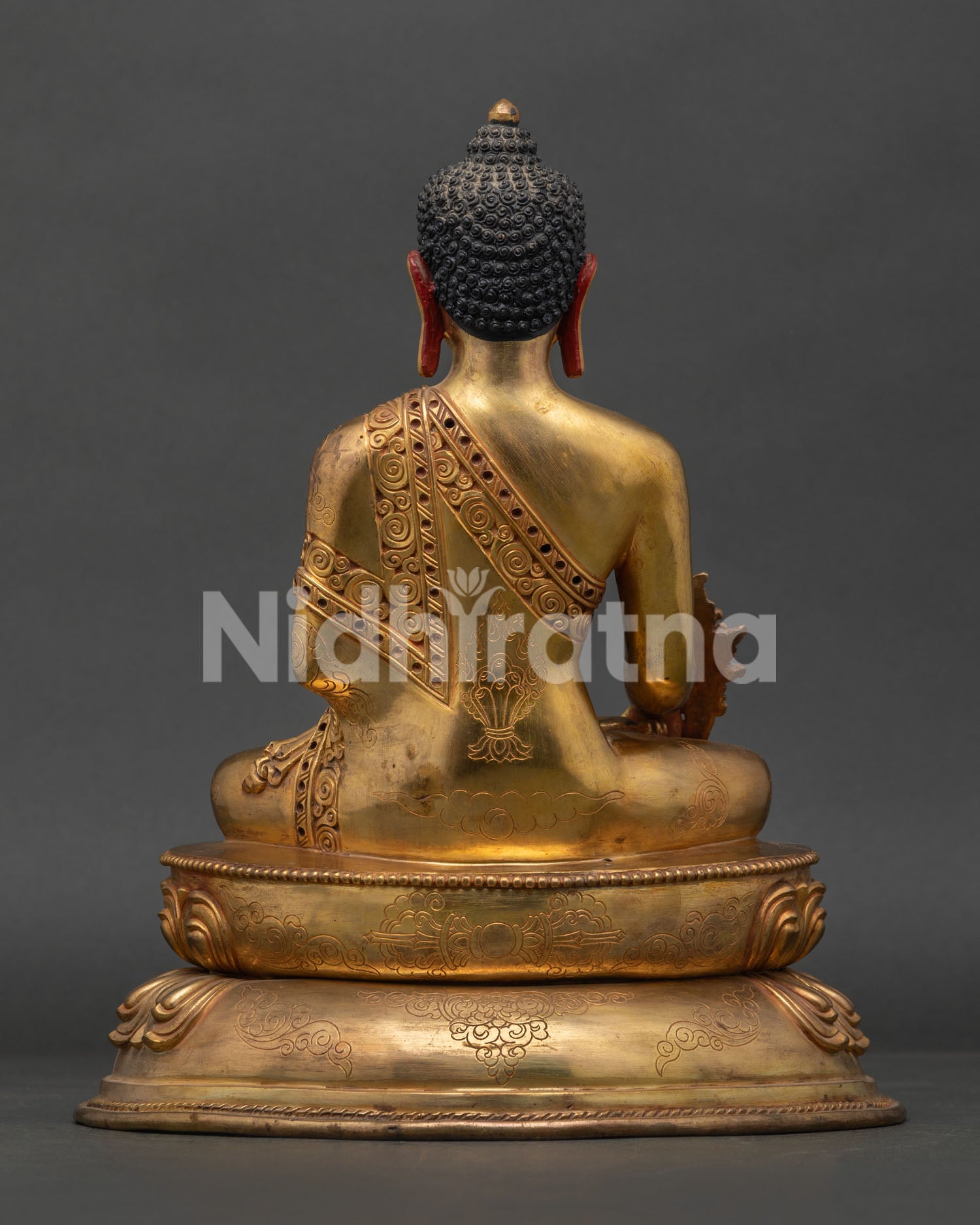 back view of medicine buddha statue with detailed robe carvings and handcrafted copper work