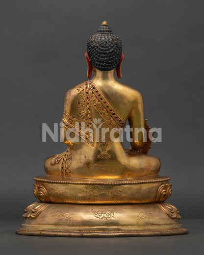 back view of medicine buddha statue with detailed robe carvings and handcrafted copper work