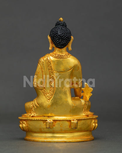 back view of nepalese copper medicine buddha statue with halo and lotus stand