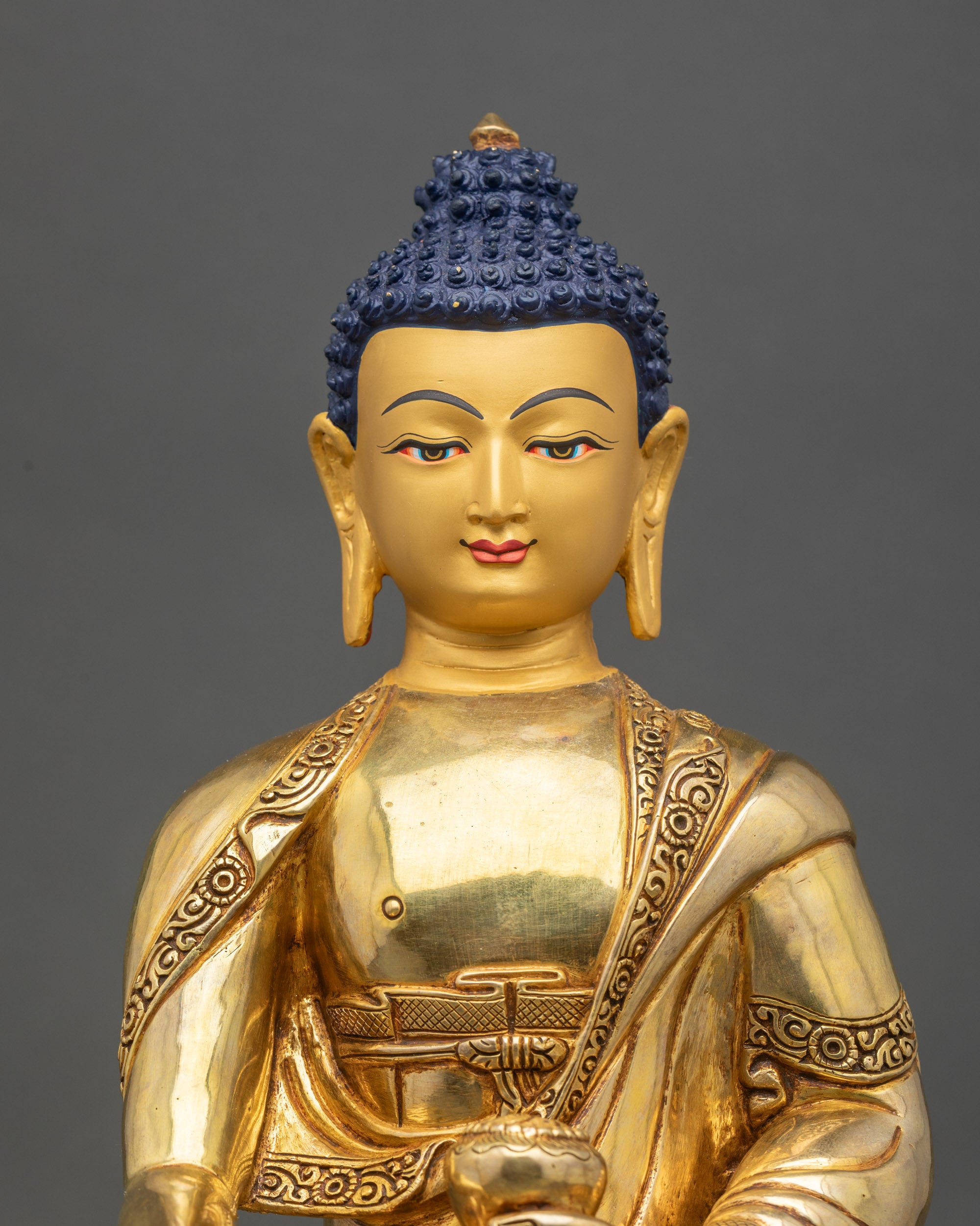 Face close-up of Buddha statue with serene expression and gold-painted features