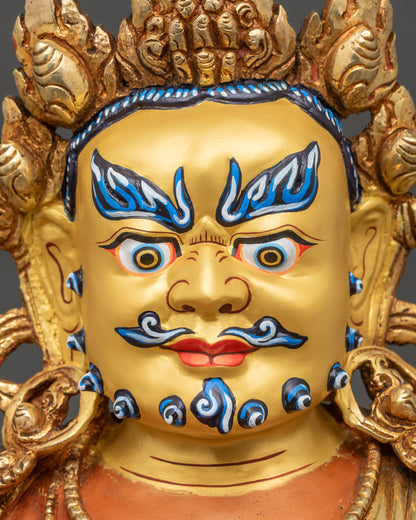 Face close-up of Dzambhala with gold-painted semi-wrathful expression