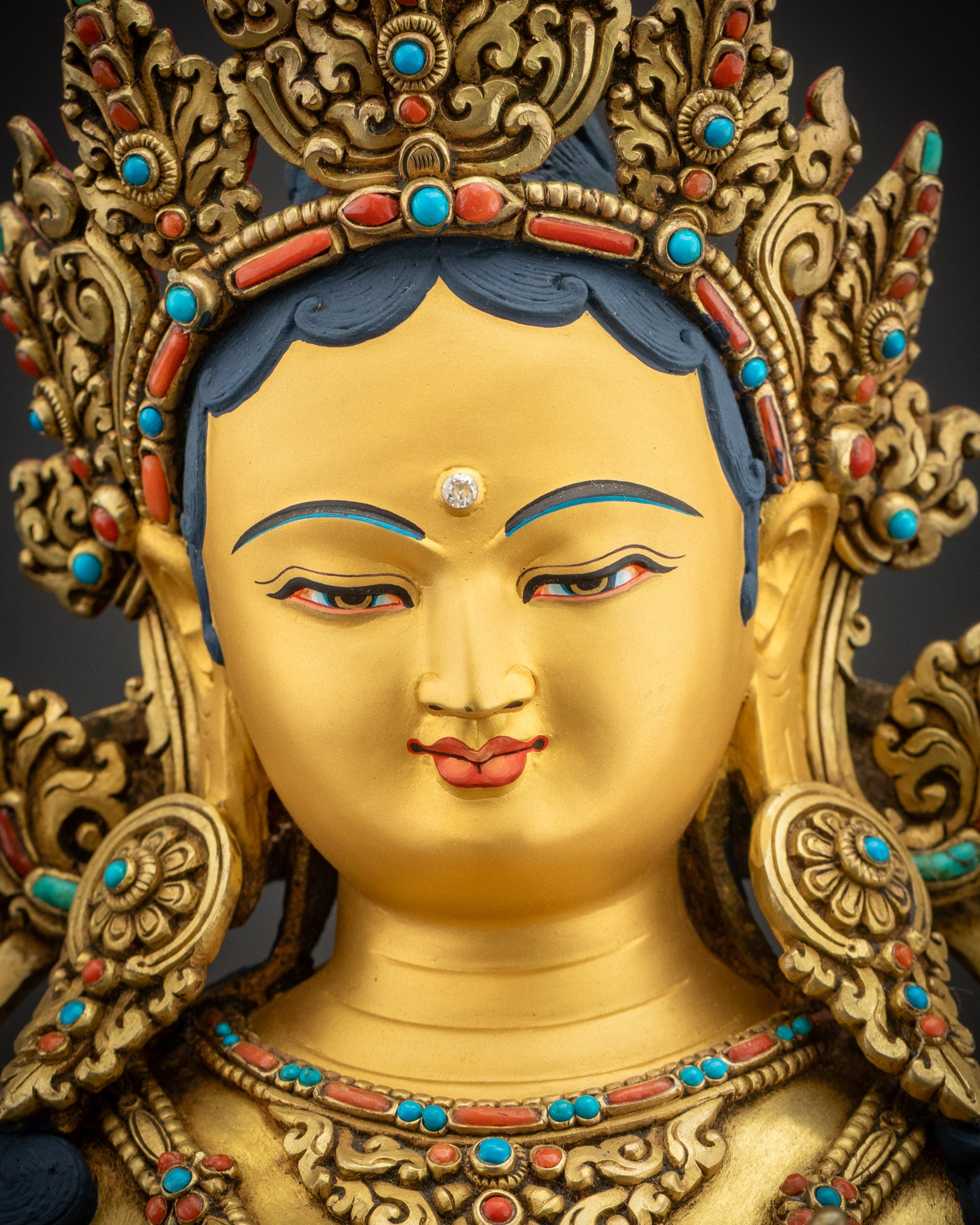 Face close up Green Tara Statue with serene expression, semi-precious stones, and gold gilding