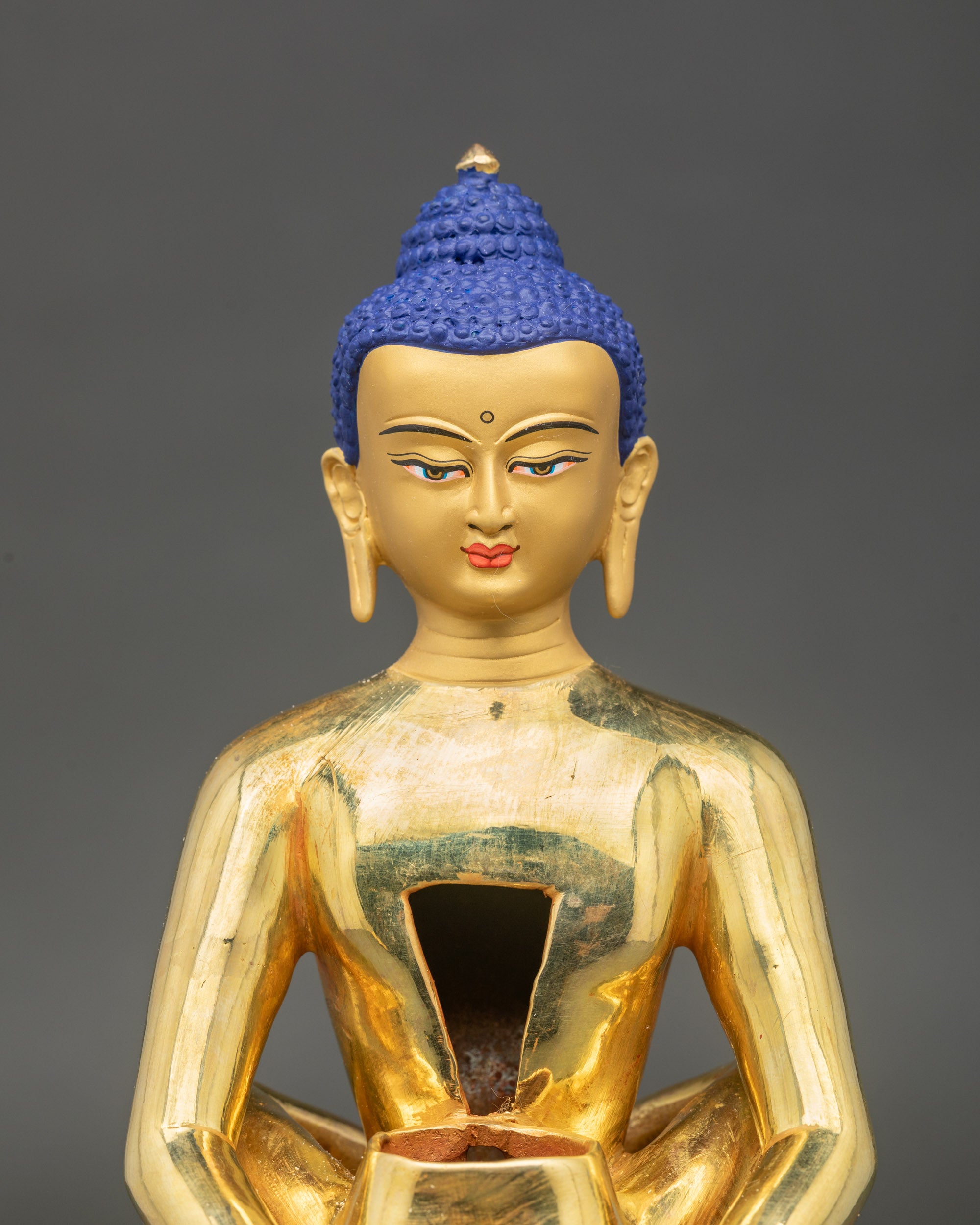 Face close up of Samantabhadra Primordial Buddha, serene gold gilded detail