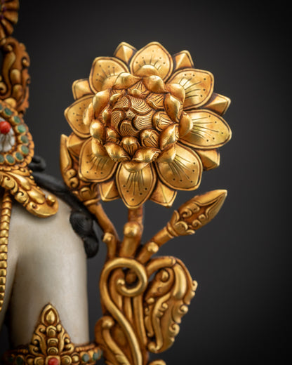 Flower beside shoulder close up of Padmapani statue with delicate petals