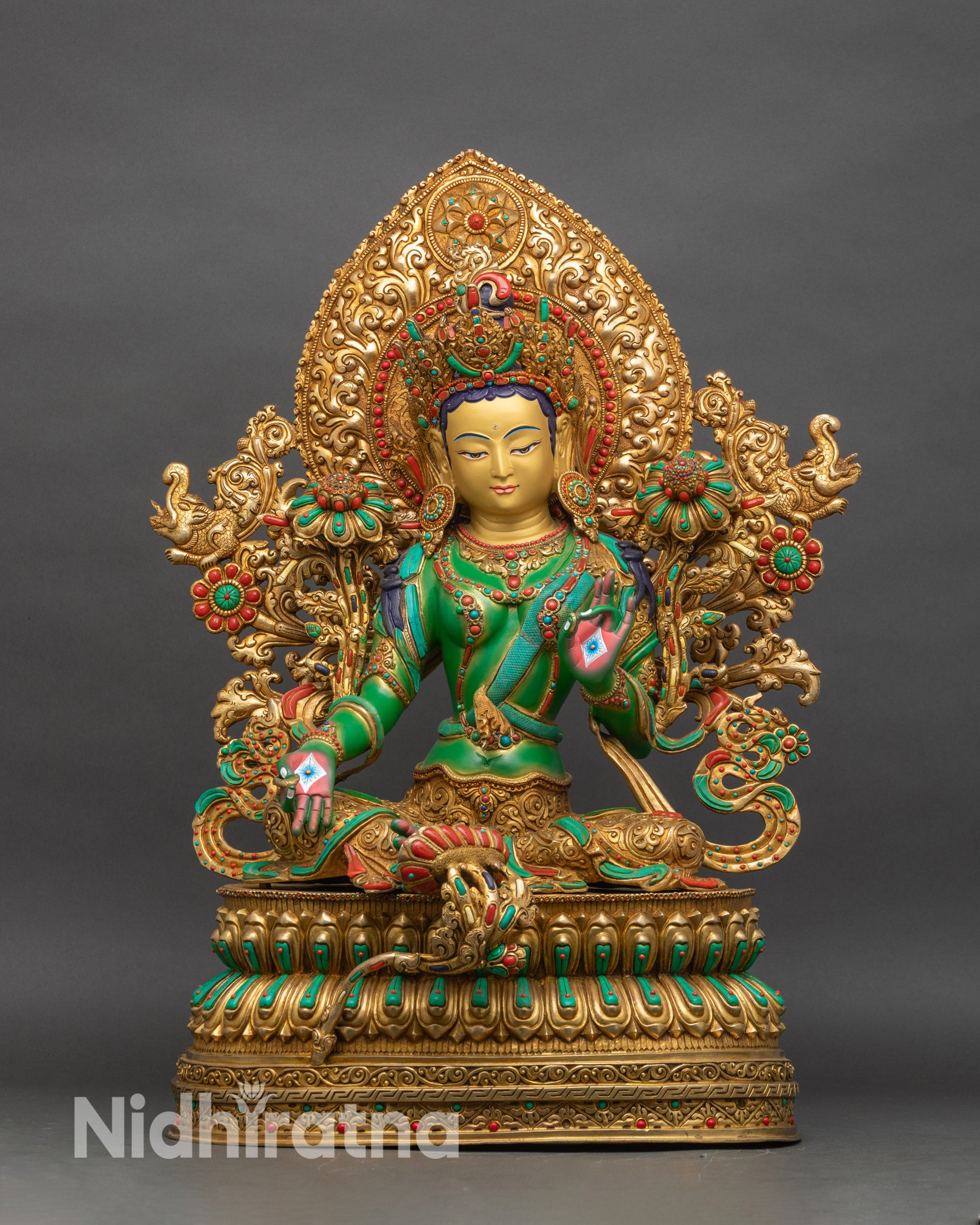 Front view of Green Tara statue, copper and gold-gilded, seated on double lotus pedestal