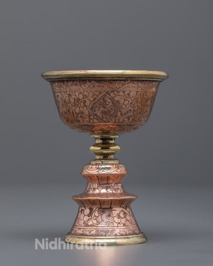 Front angle of hand-carved copper butter lamp used in Tibetan Buddhist rituals