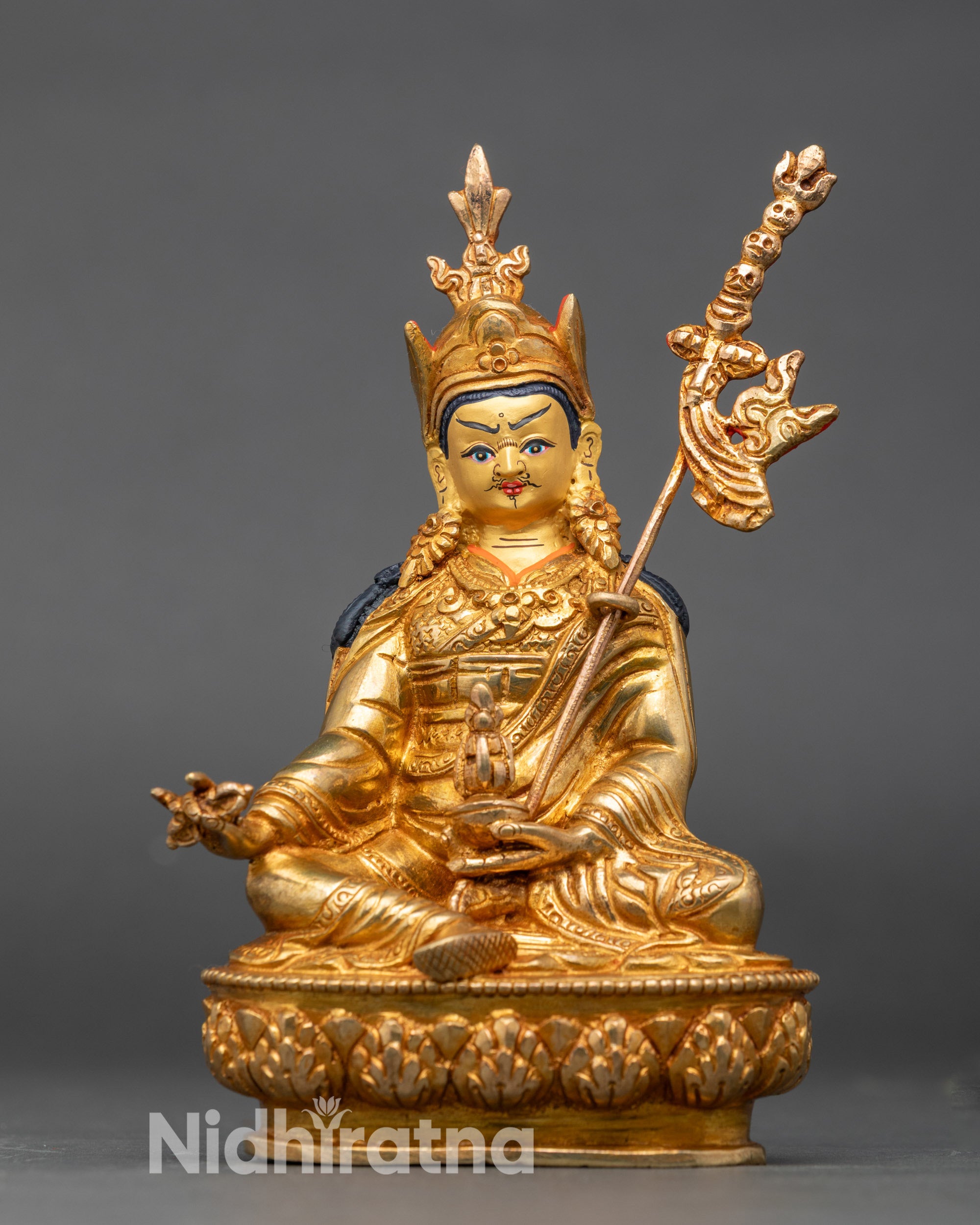Front profile of Guru Rinpoche statue with serene expression and detailed copper craftsmanship