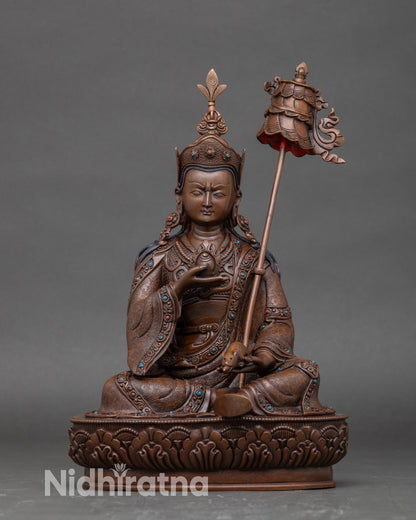 Front view Guru Norlha statue on lotus pedestal, copper oxidized artisan crafted sculpture