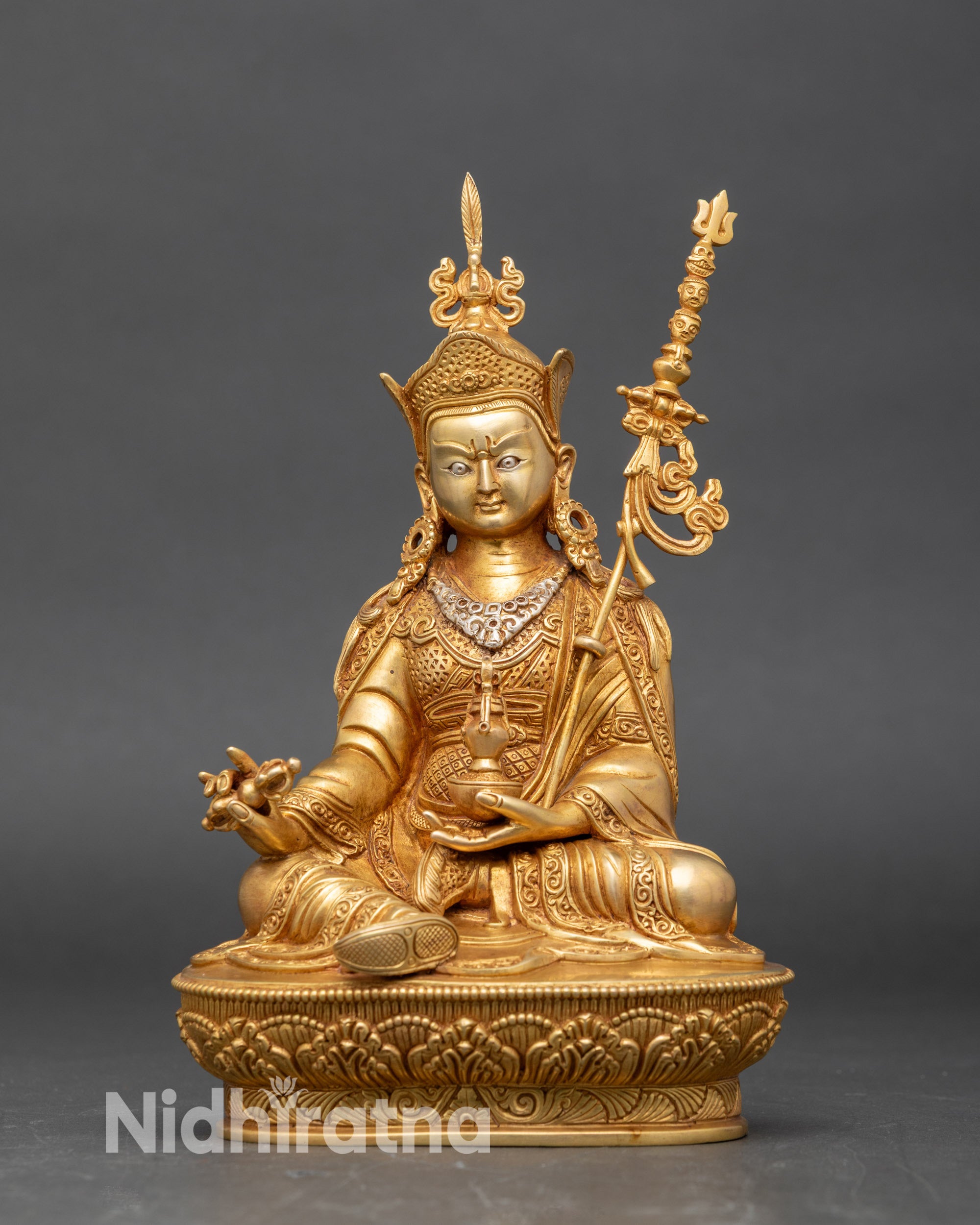 Front view Guru Rinpoche statue, copper with gold accents, seated on lotus pedestal