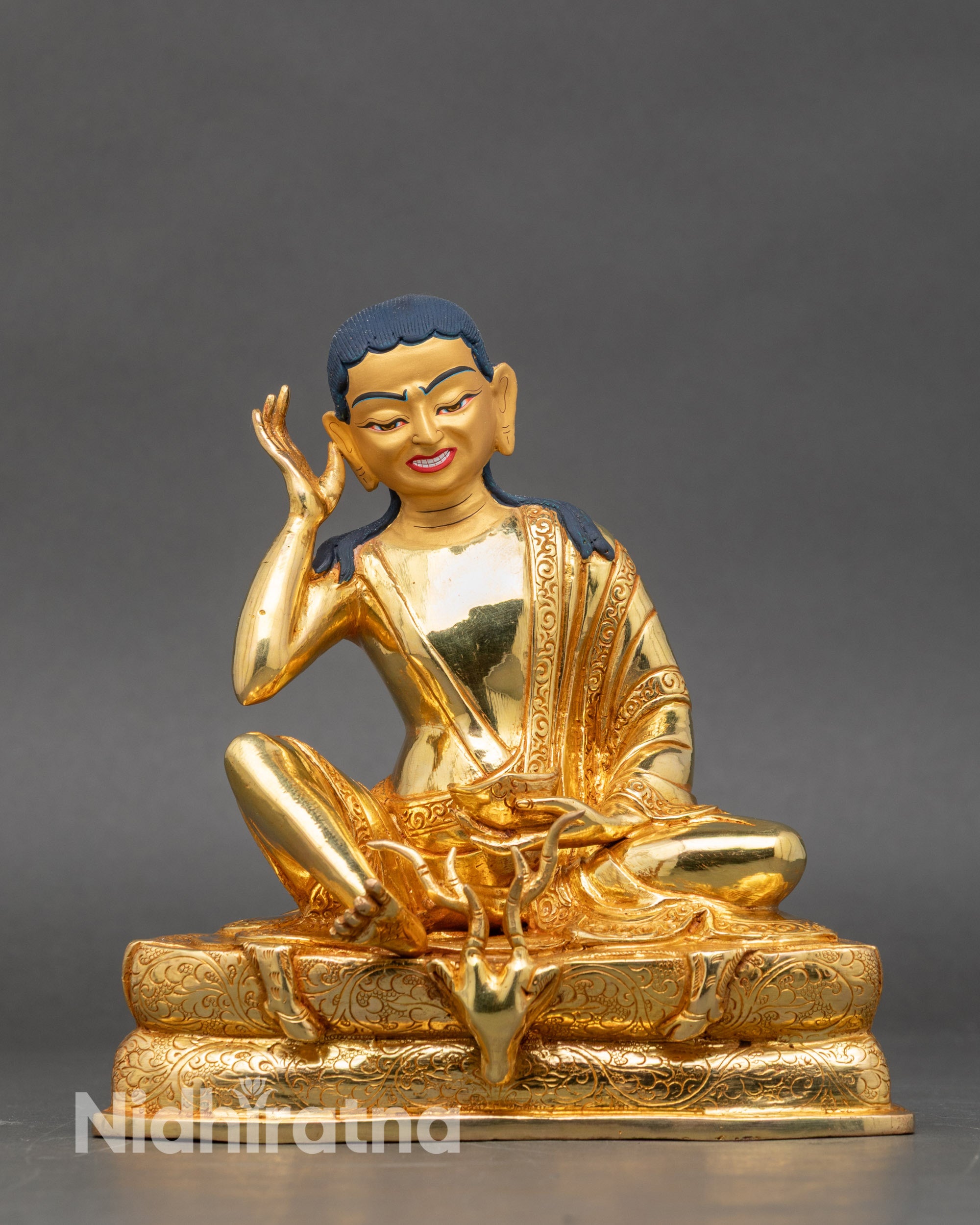 Front view – Handcrafted Milarepa statue seated on engraved deer skin pedestal, gold-gilded