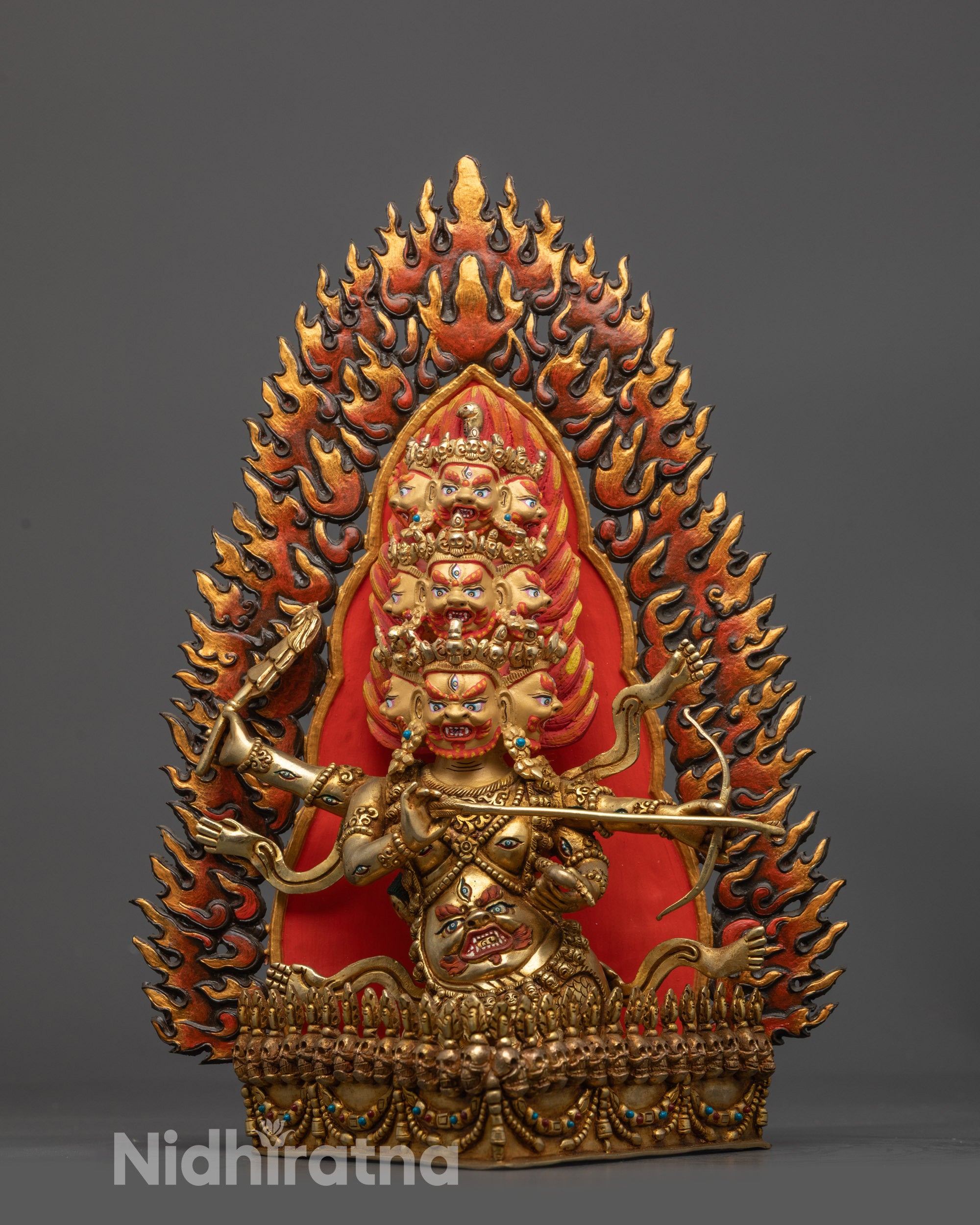 Front view Rahula statue with nine heads and flaming halo
